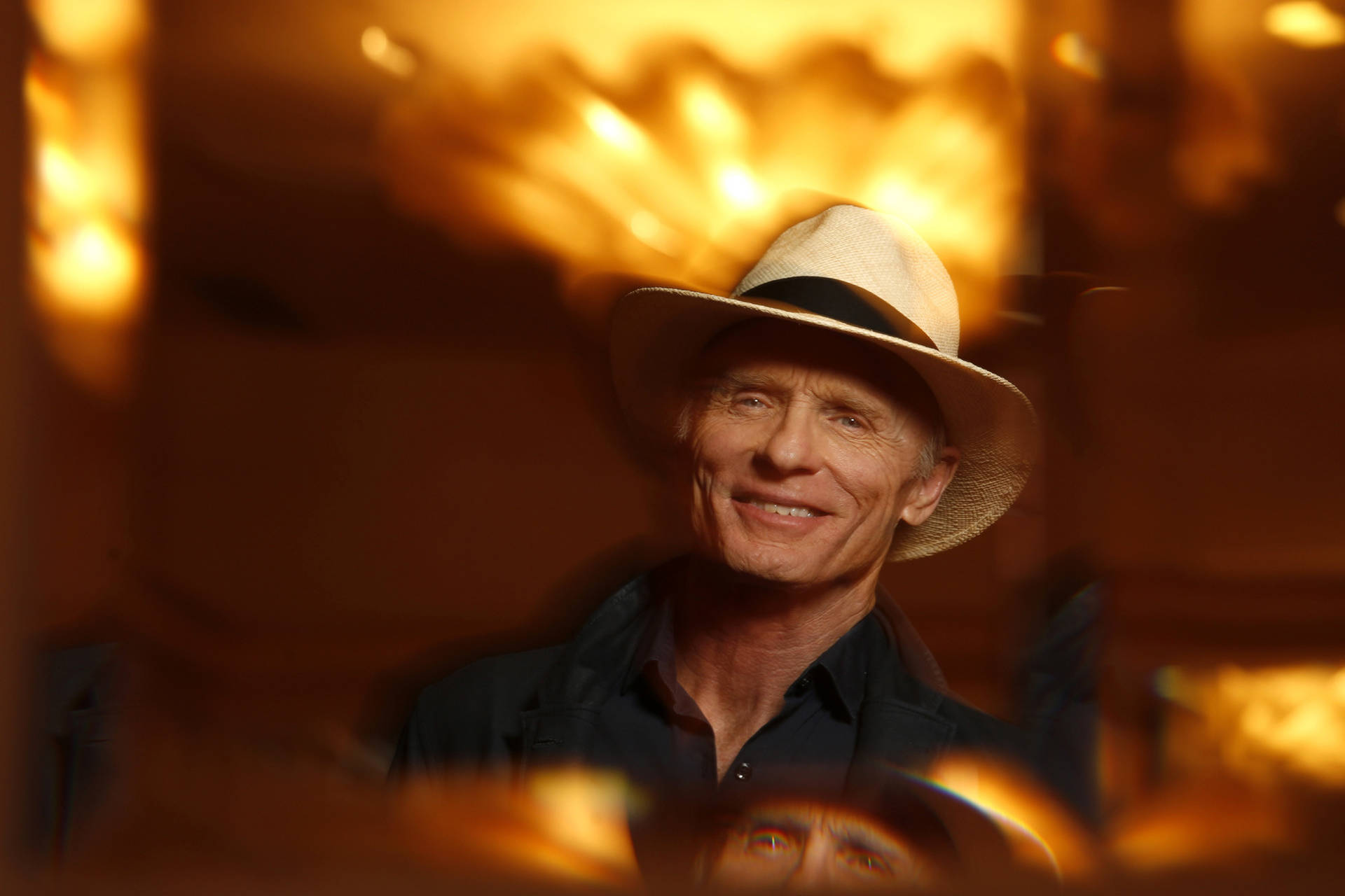 Smiling American Actor Ed Harris With Yellow Lights Wallpaper