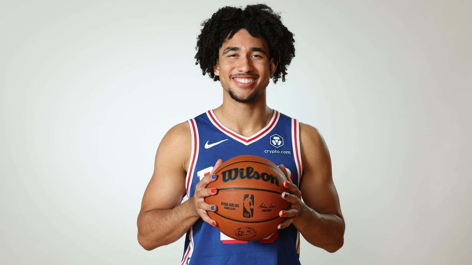 Smiling Basketball Player Holding Ball Wallpaper