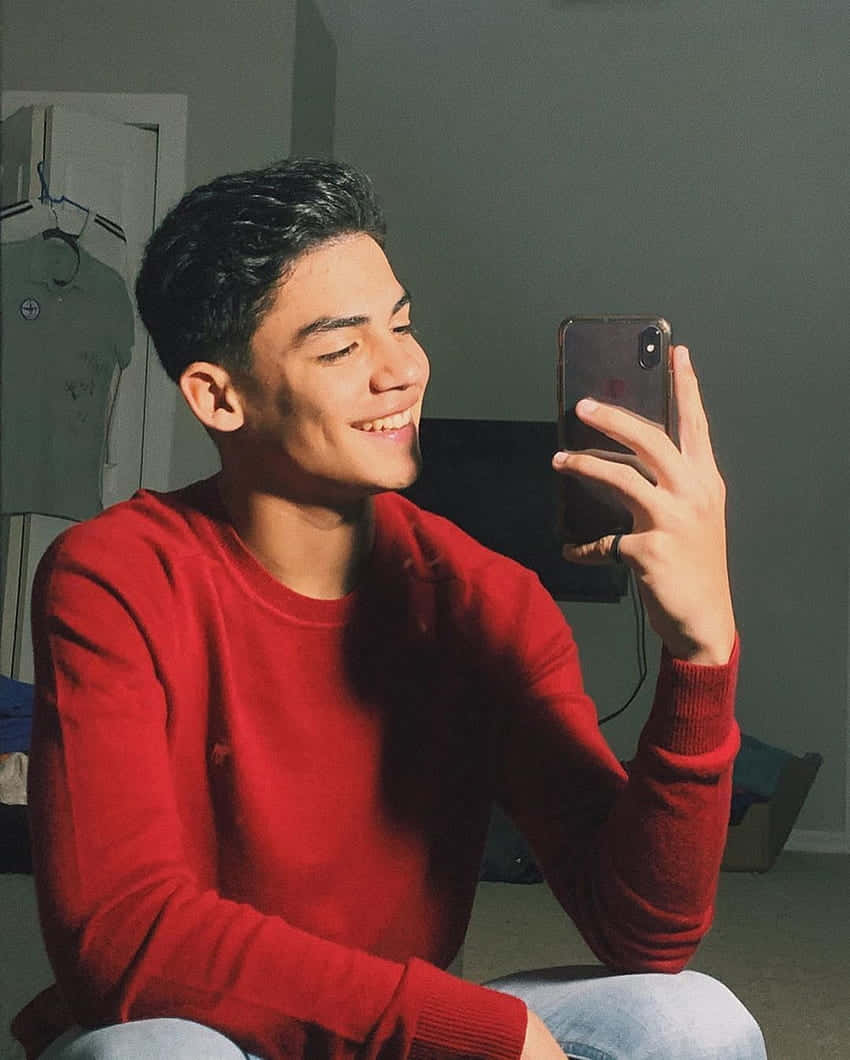 Smiling_ Boy_ Taking_ Selfie_ Red_ Sweater Wallpaper