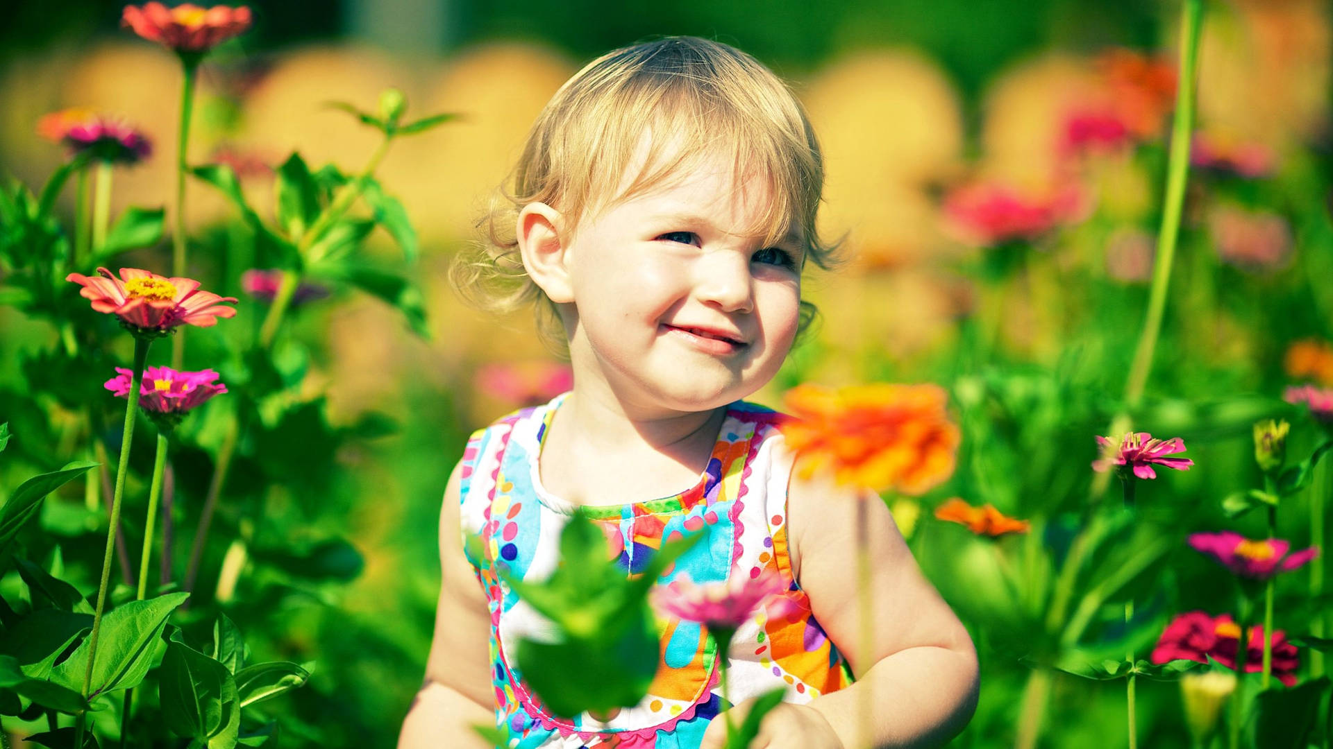 Smiling Child In A Flower Garden Wallpaper