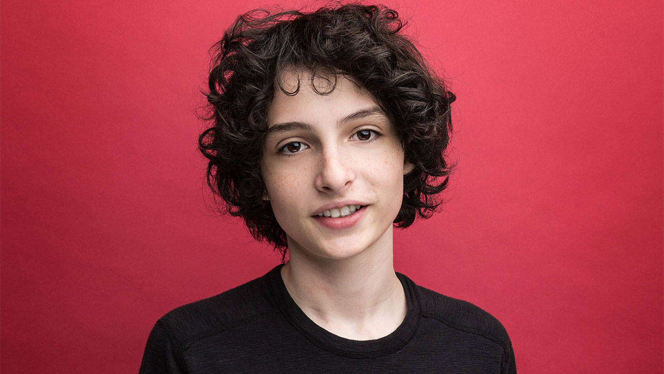 Smiling Curly-haired Finn Wolfhard Wallpaper