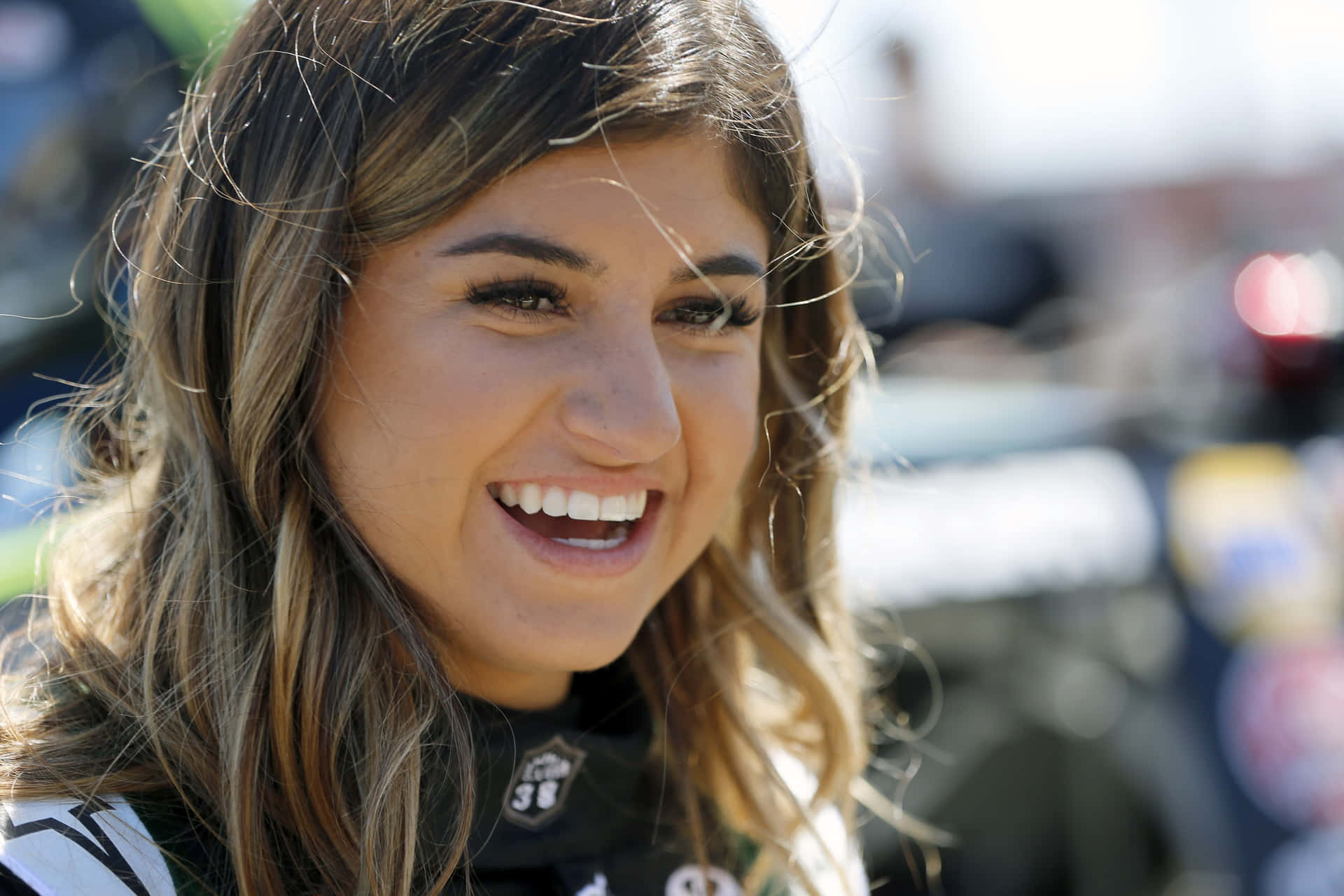 Smiling Female Racecar Driver Outdoors Wallpaper