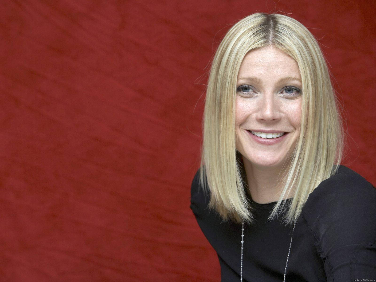 Smiling Hollywood Actress Gwyneth Paltrow Red Background Wallpaper