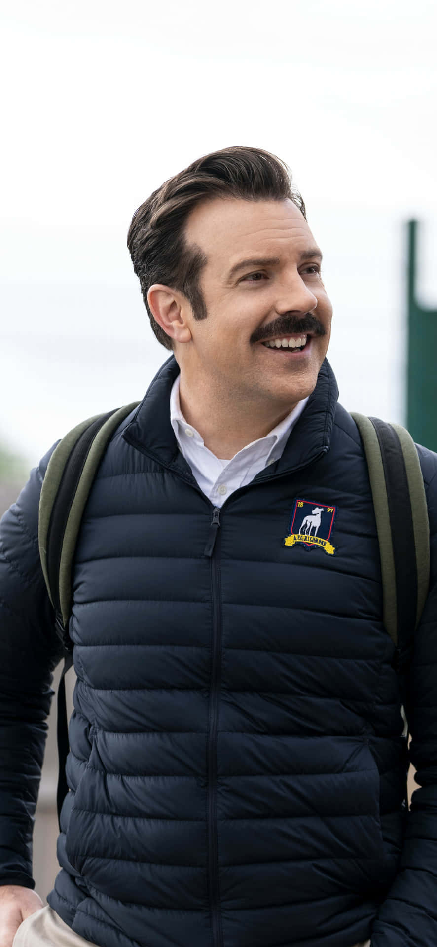 Smiling Man With Backpack Ted Lasso Inspired Wallpaper