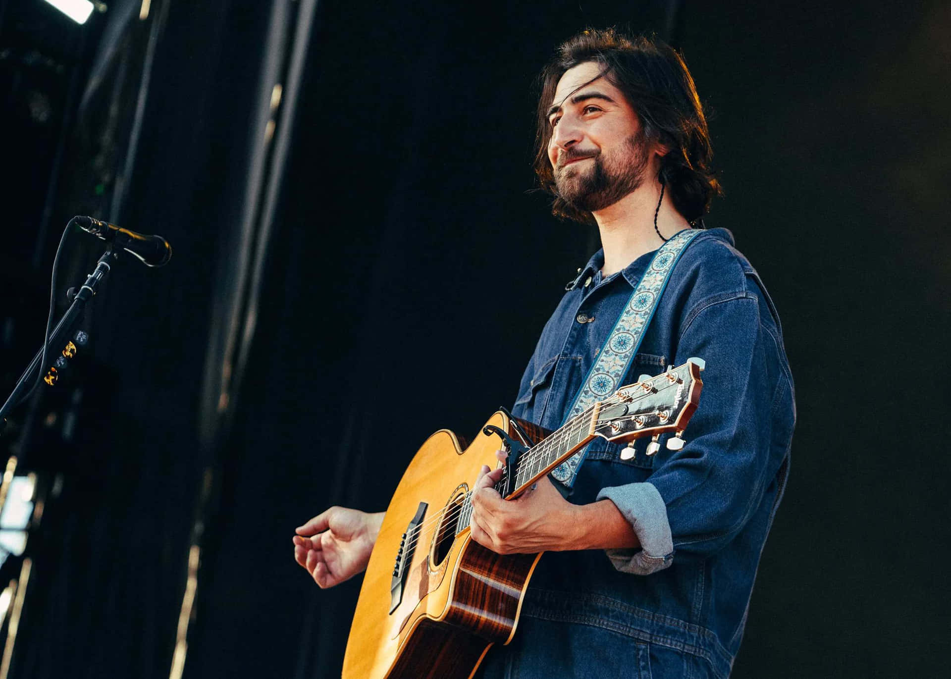 Smiling Musician With Guitar On Stage.jpg Wallpaper