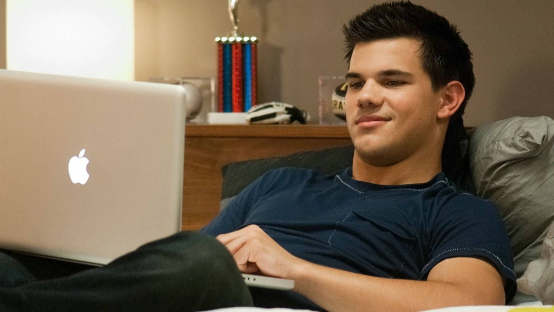 Smiling Taylor Lautner With Laptop Wallpaper