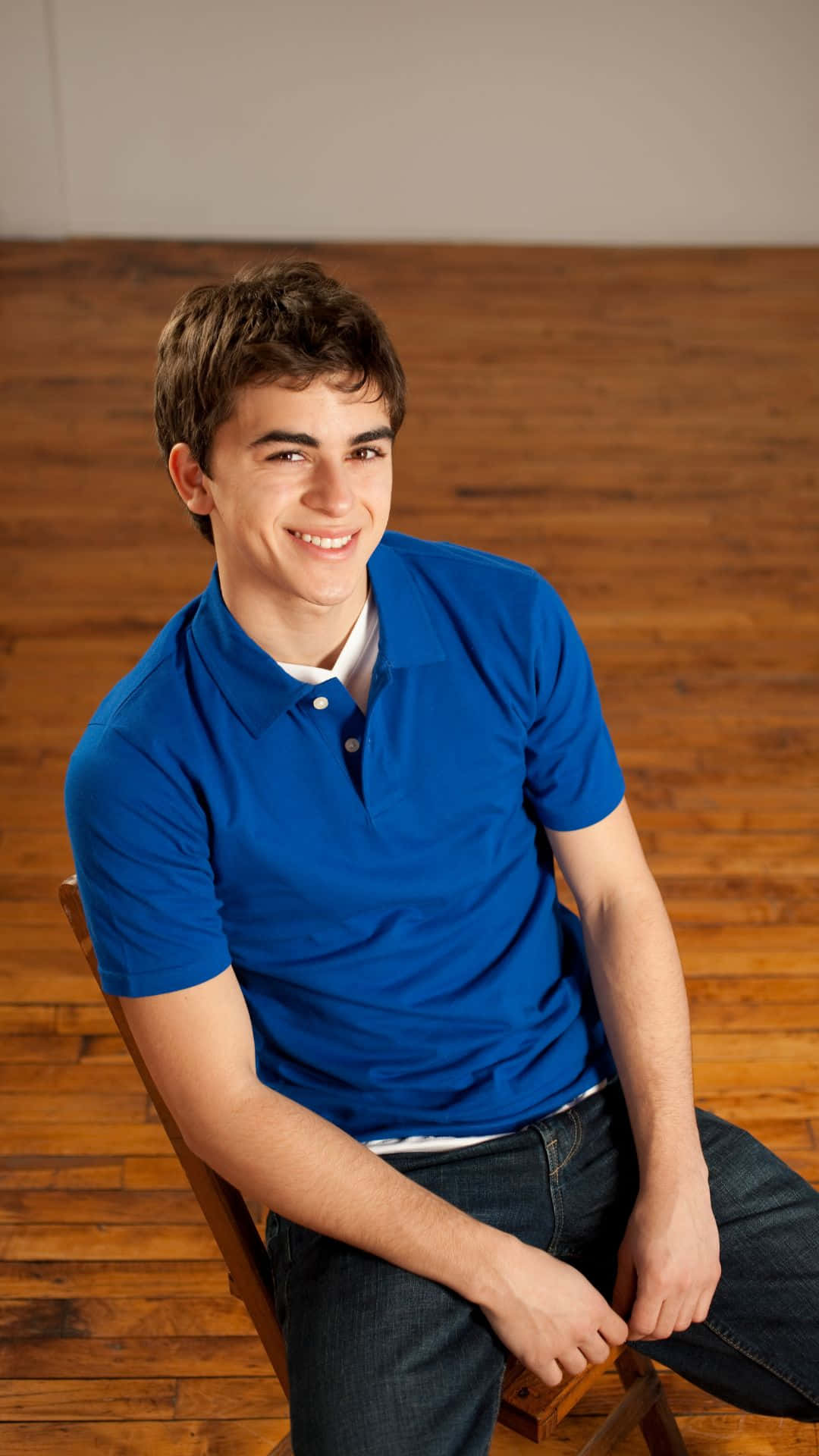 Smiling Teen Boy Blue Shirt Wallpaper