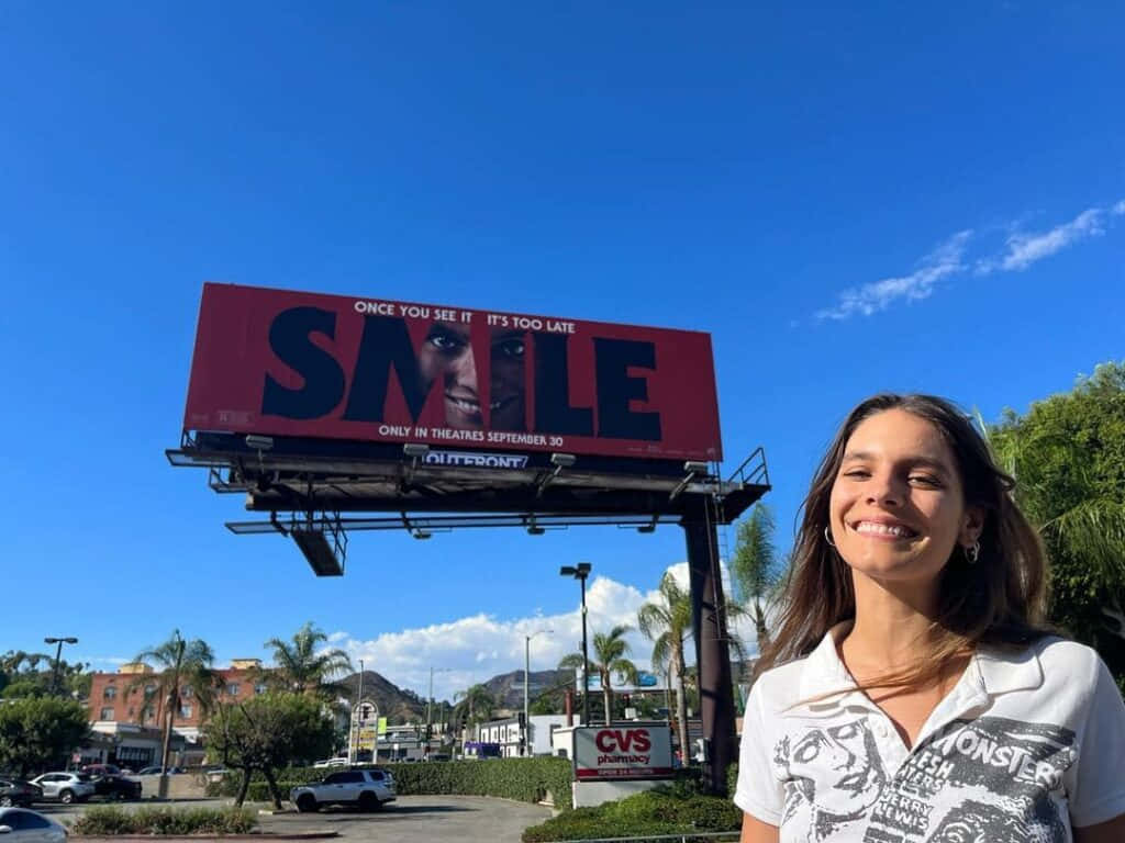 Smiling Woman Billboard Movie Promotion Wallpaper
