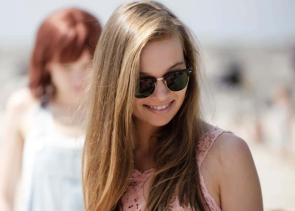 Glunderende Vrouw Met Zonnebril Op Het Strand Achtergrond