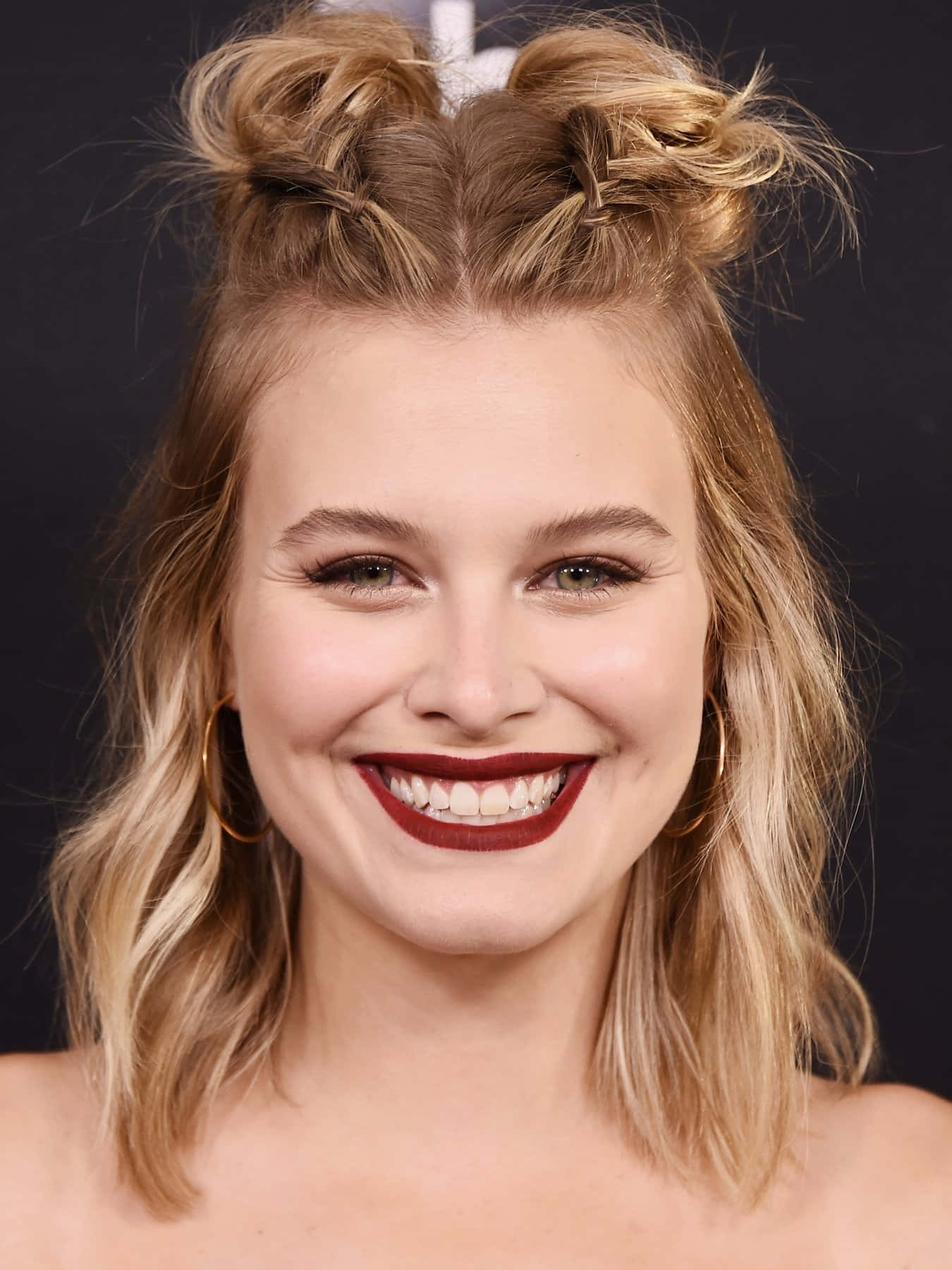 Smiling Womanwith Buns Hairstyleand Red Lipstick Wallpaper