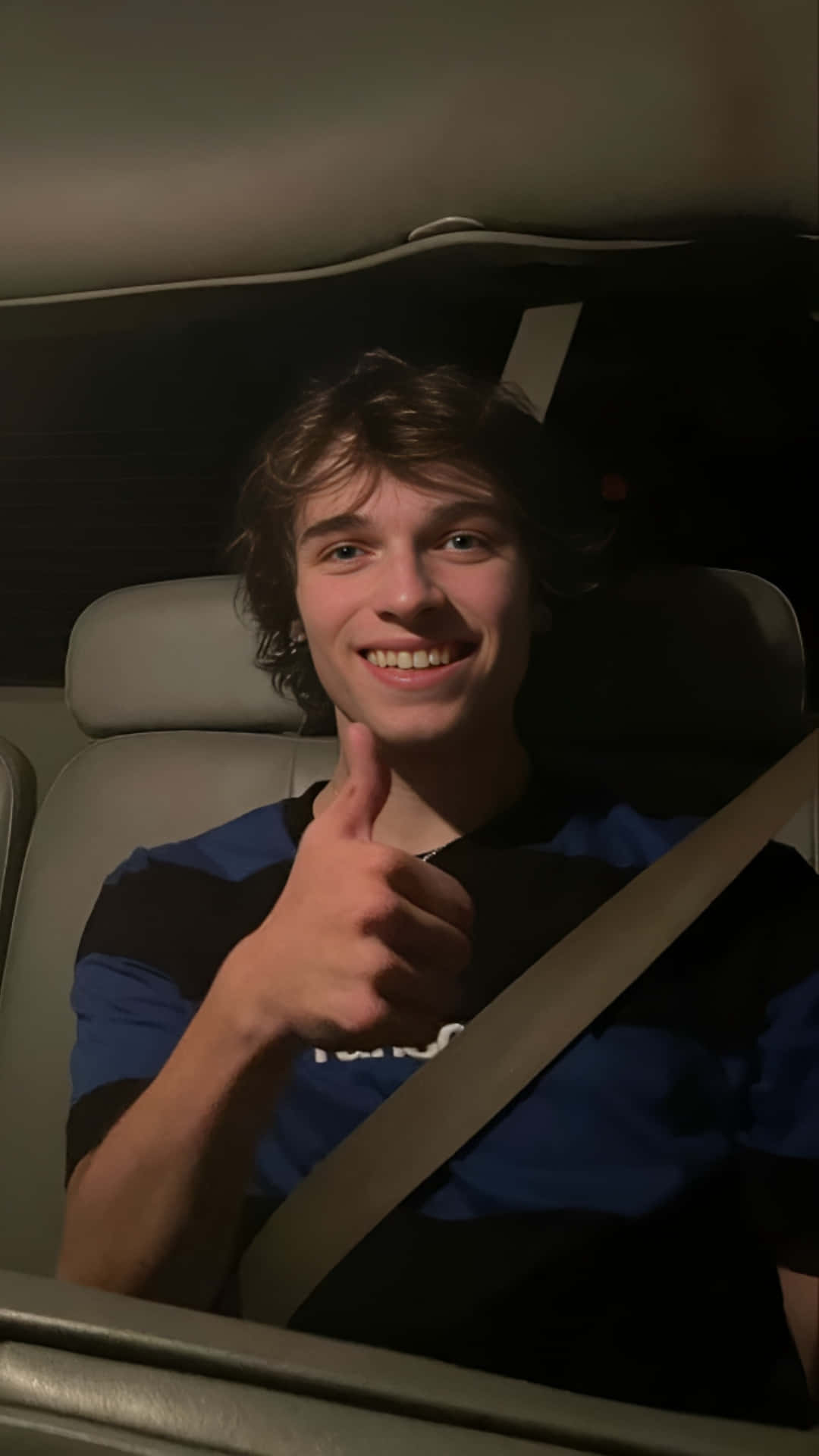 Smiling Young Man Giving Thumbs Upin Car Nighttime Wallpaper