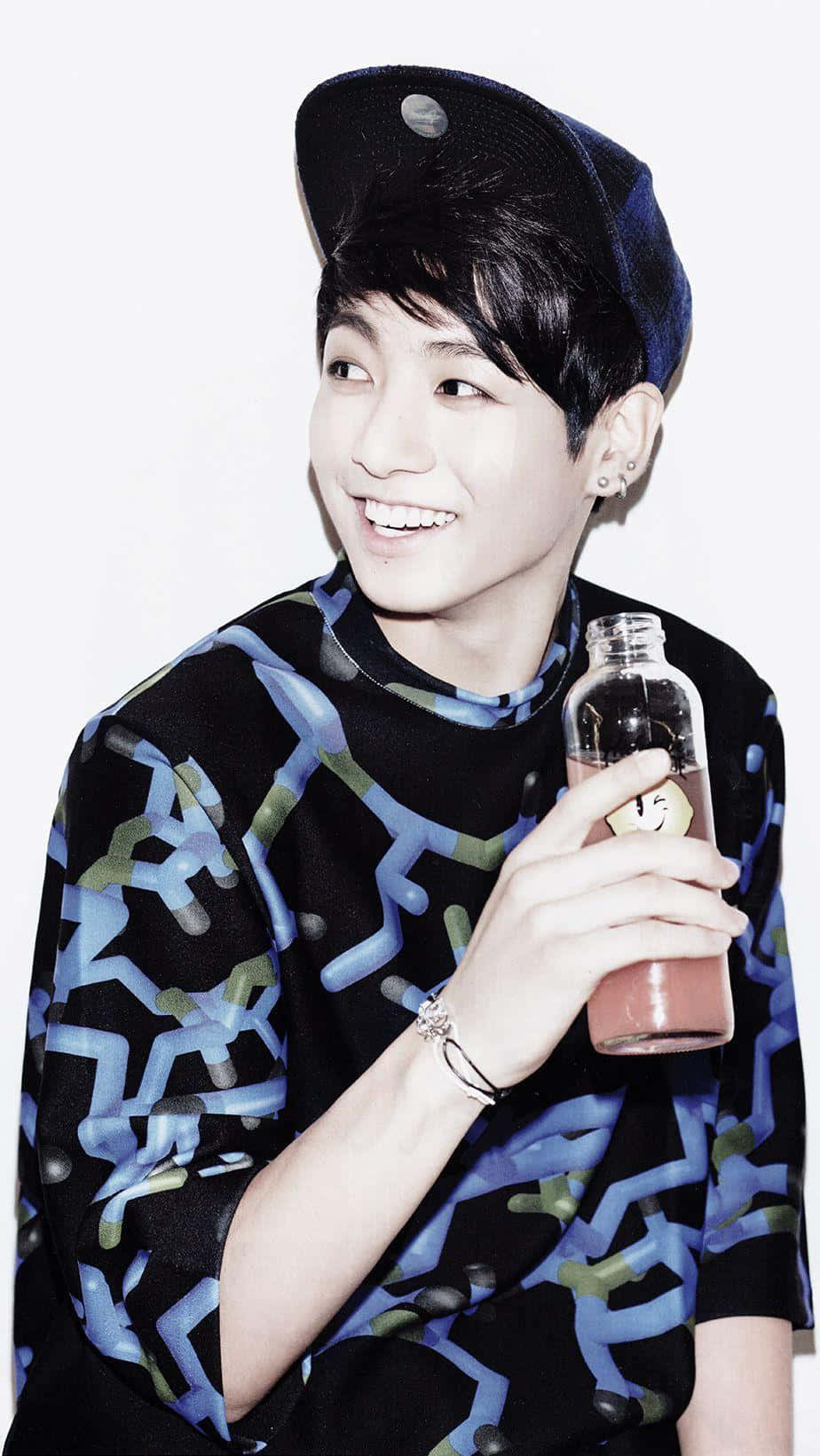 Smiling_ Youth_with_ Cap_and_ Beverage.jpg Wallpaper