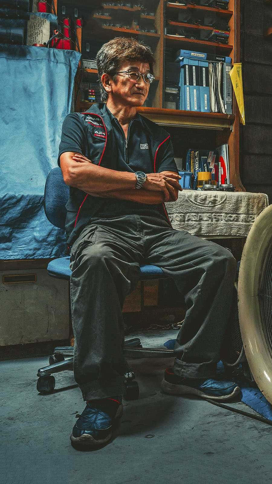 Smokey Nagata Sitting Inside A Repair Shop Wallpaper