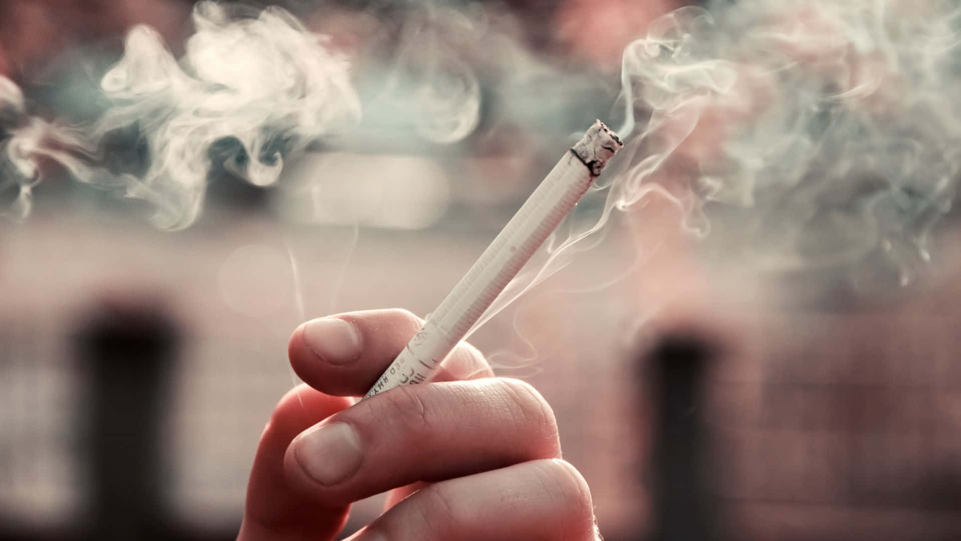 Enperson Holder En Cigaret Med Røg, Der Kommer Ud Af Den.
