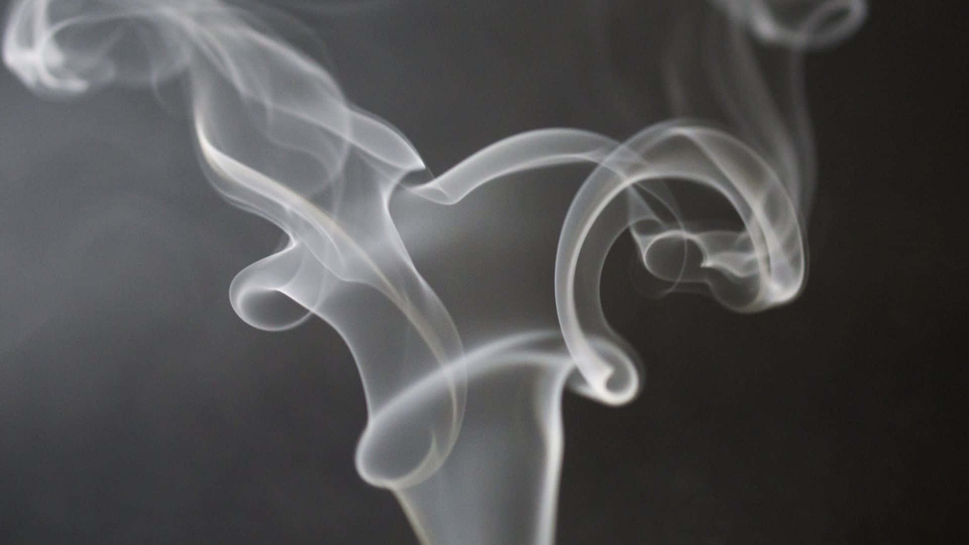 A White Smoke Is Rising Up From A Black Background