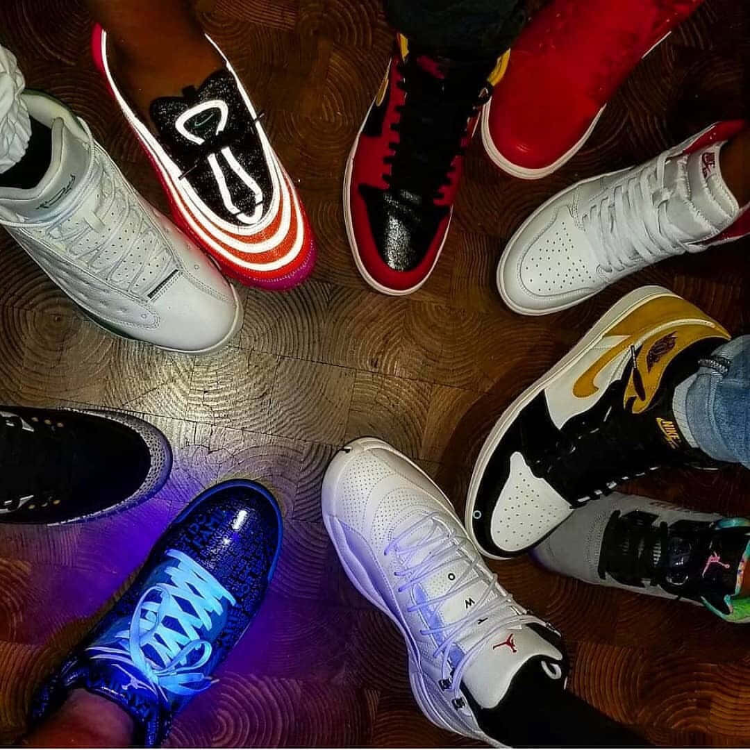 A Group Of People Standing Around A Table With Shoes On Wallpaper