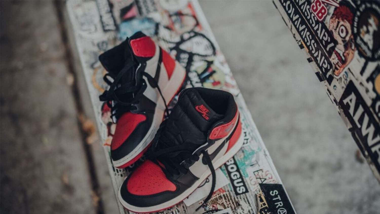 Et par af Air Jordan 1 High sneakers på en skateboard. Wallpaper