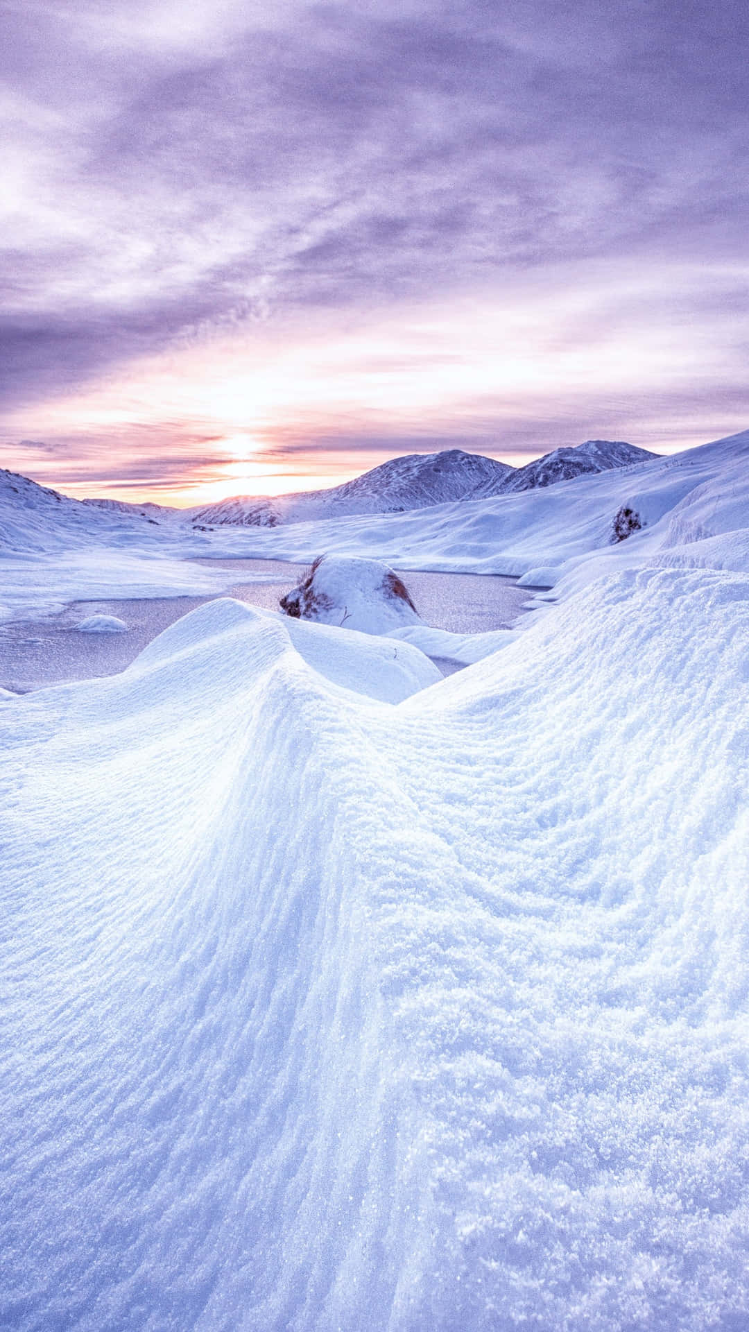 A Snow Covered Landscape With A Sunset