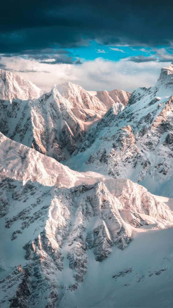 Einemit Schnee Bedeckte Bergkette Mit Wolken Am Himmel Wallpaper
