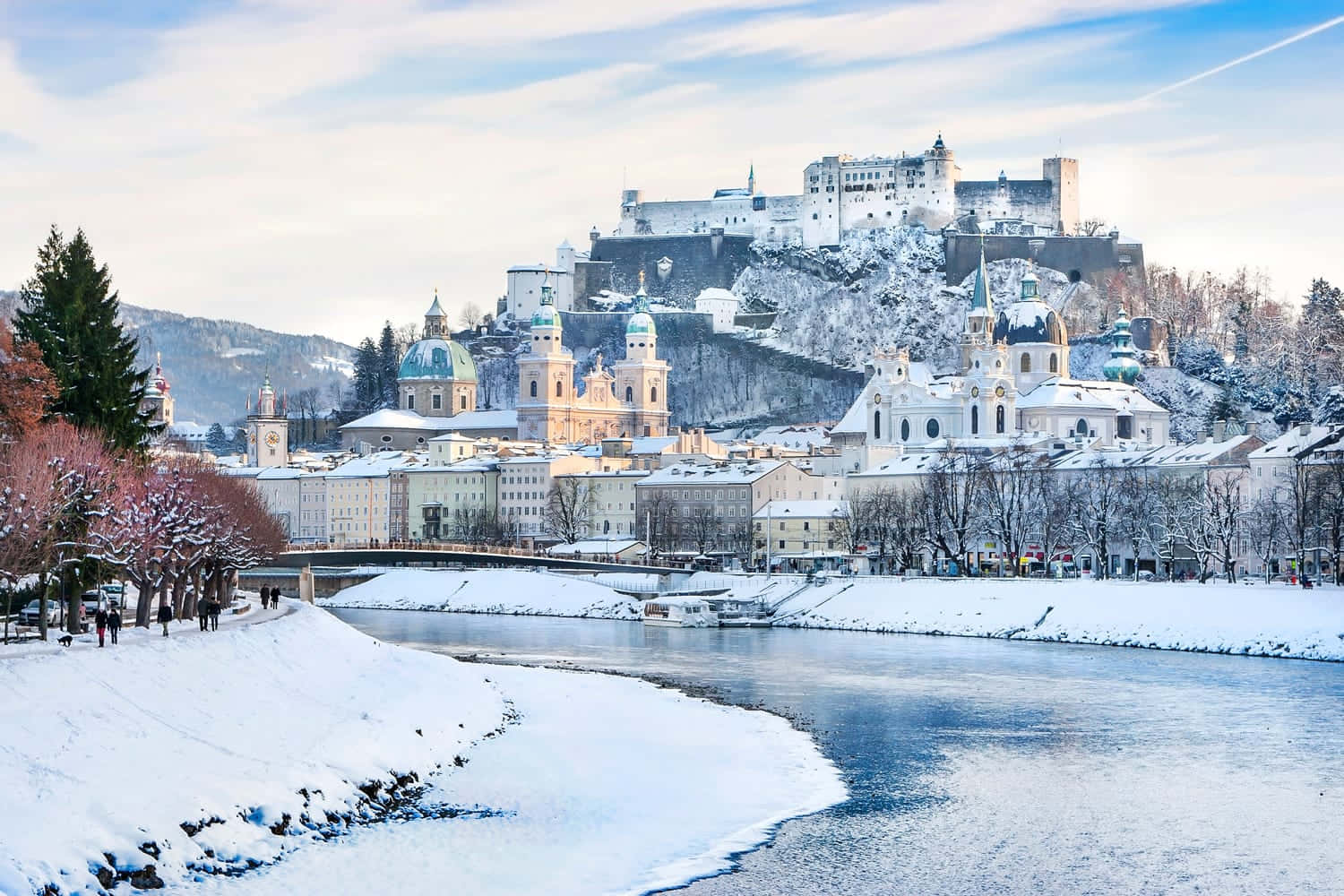 Salzburg om vinteren med en flod og slot