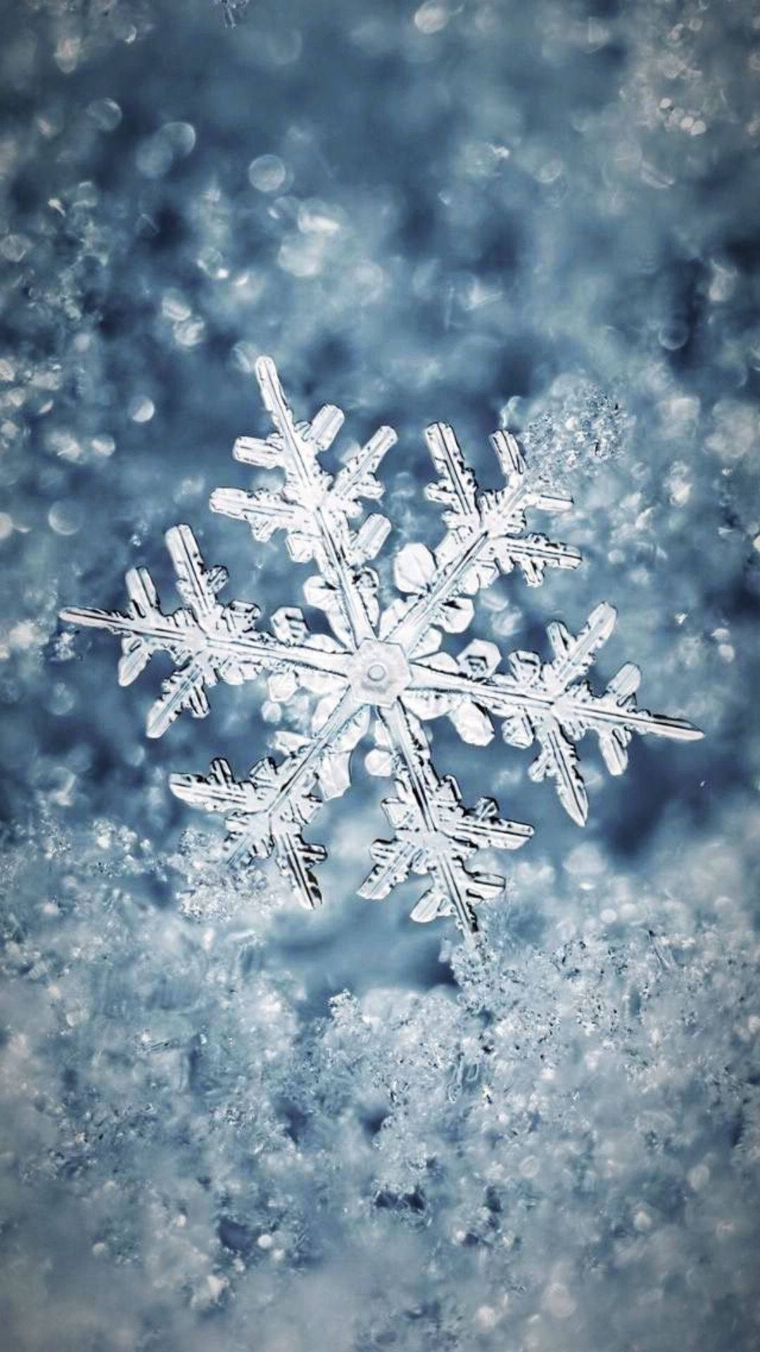 A Snowflake Is Sitting On Top Of A Blue Surface Wallpaper