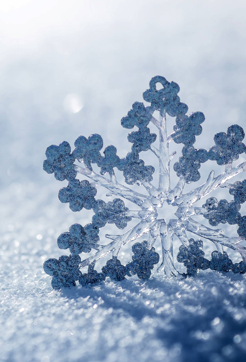 A Snowflake Is Sitting On Top Of The Snow Wallpaper