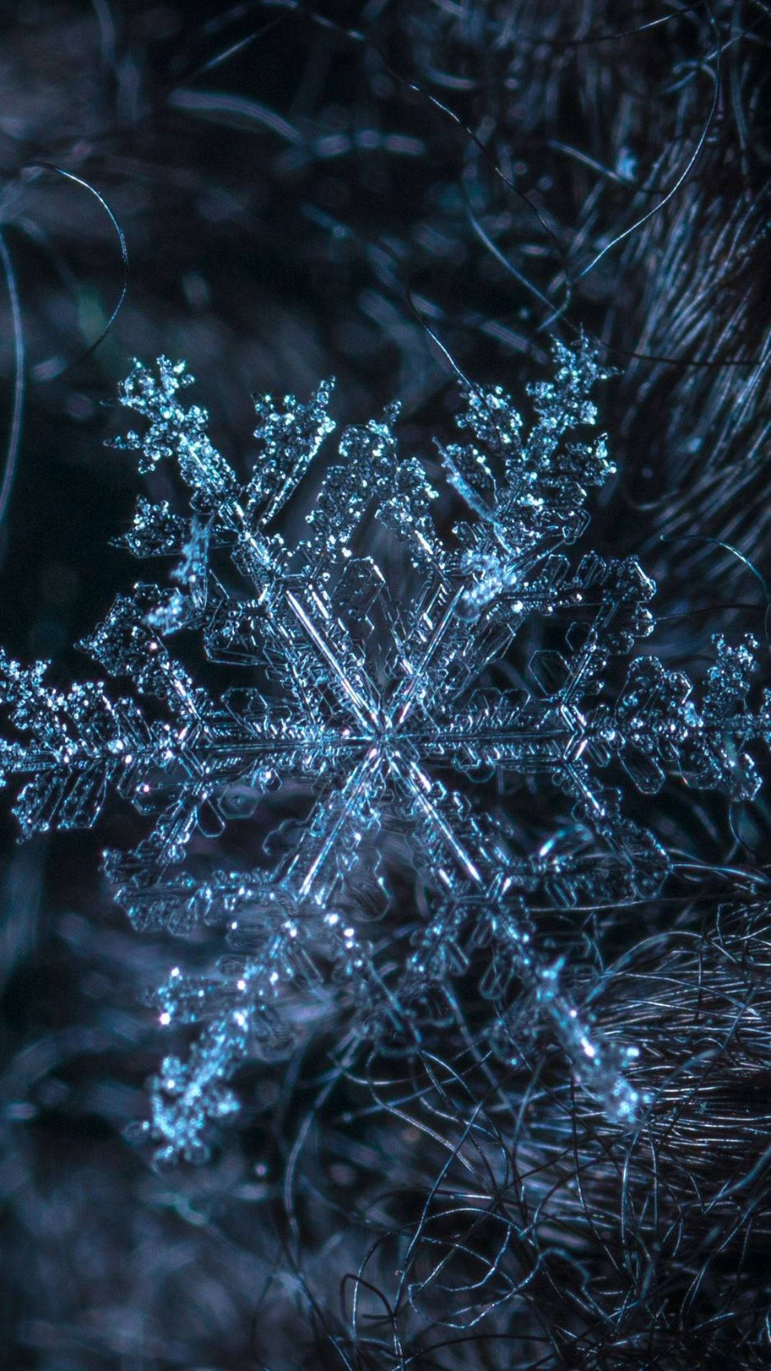A Snowflake Is Shown In The Dark Wallpaper