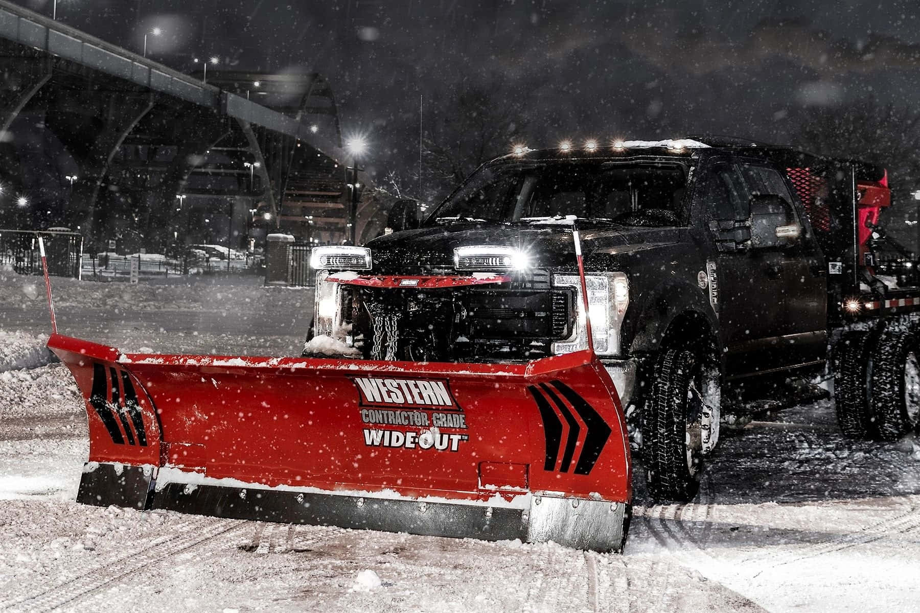 Powerful Snowplow Clearing a Snowy Road Wallpaper