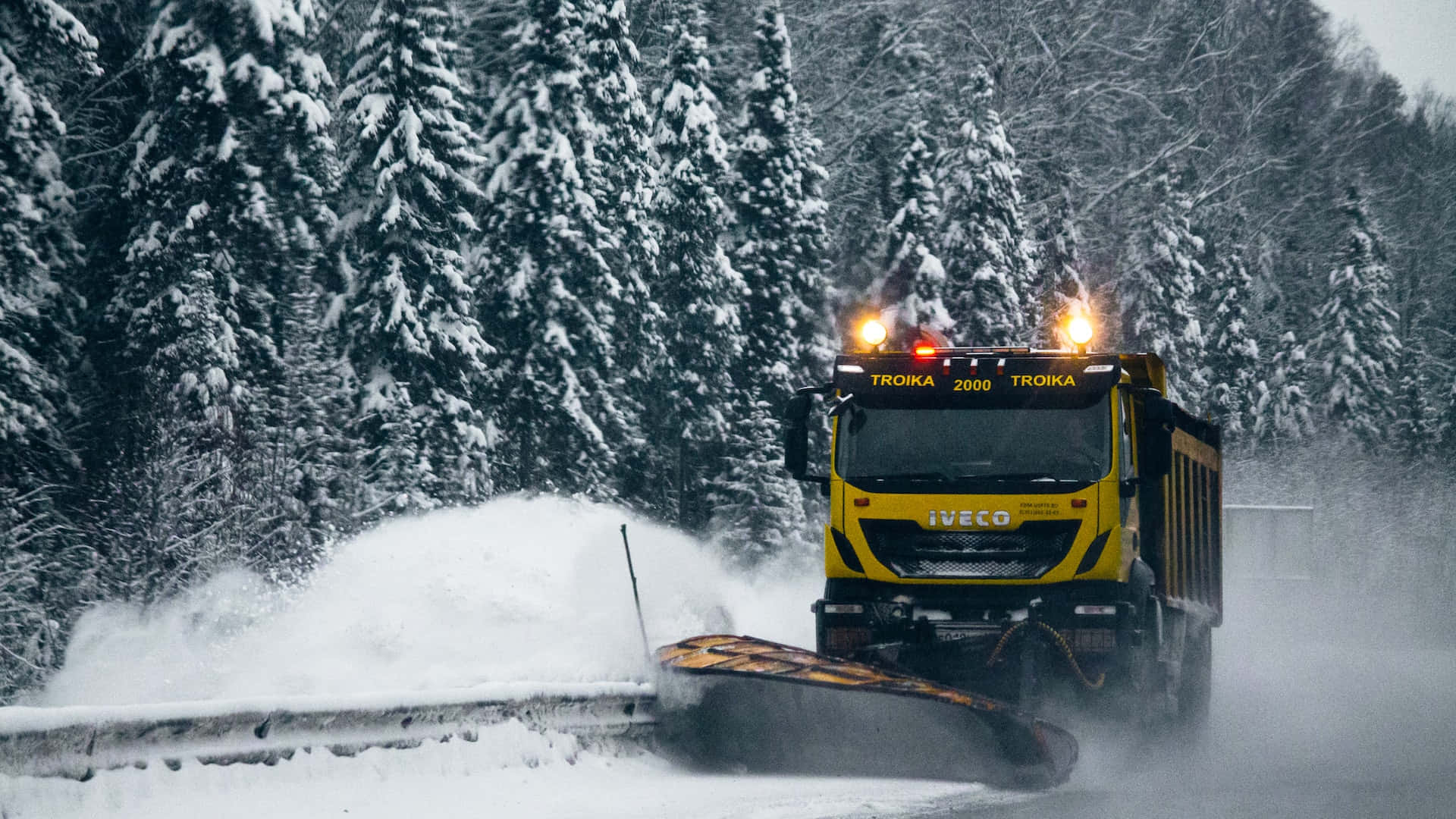 Snowplow clearing a snowy road on a winter day Wallpaper
