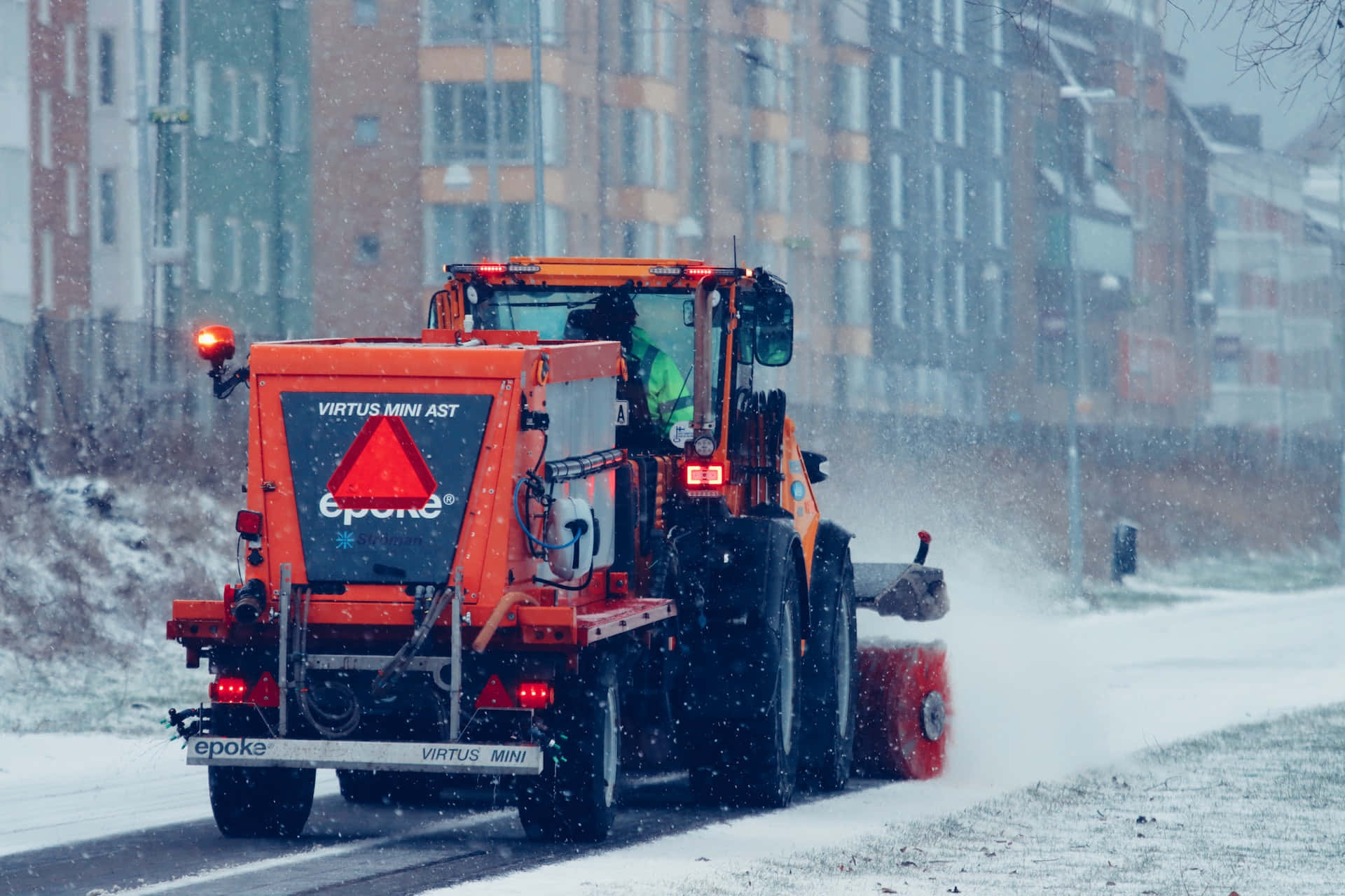 Powerful Snowplow Clearing a Road in Winter Wonderland Wallpaper