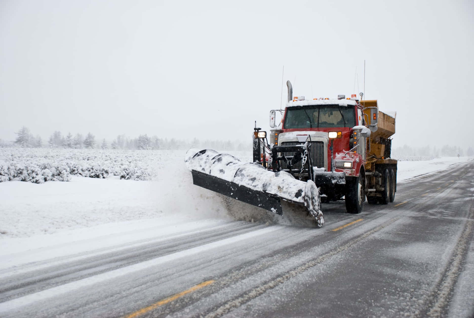 Snowplow clearing the snowy road Wallpaper