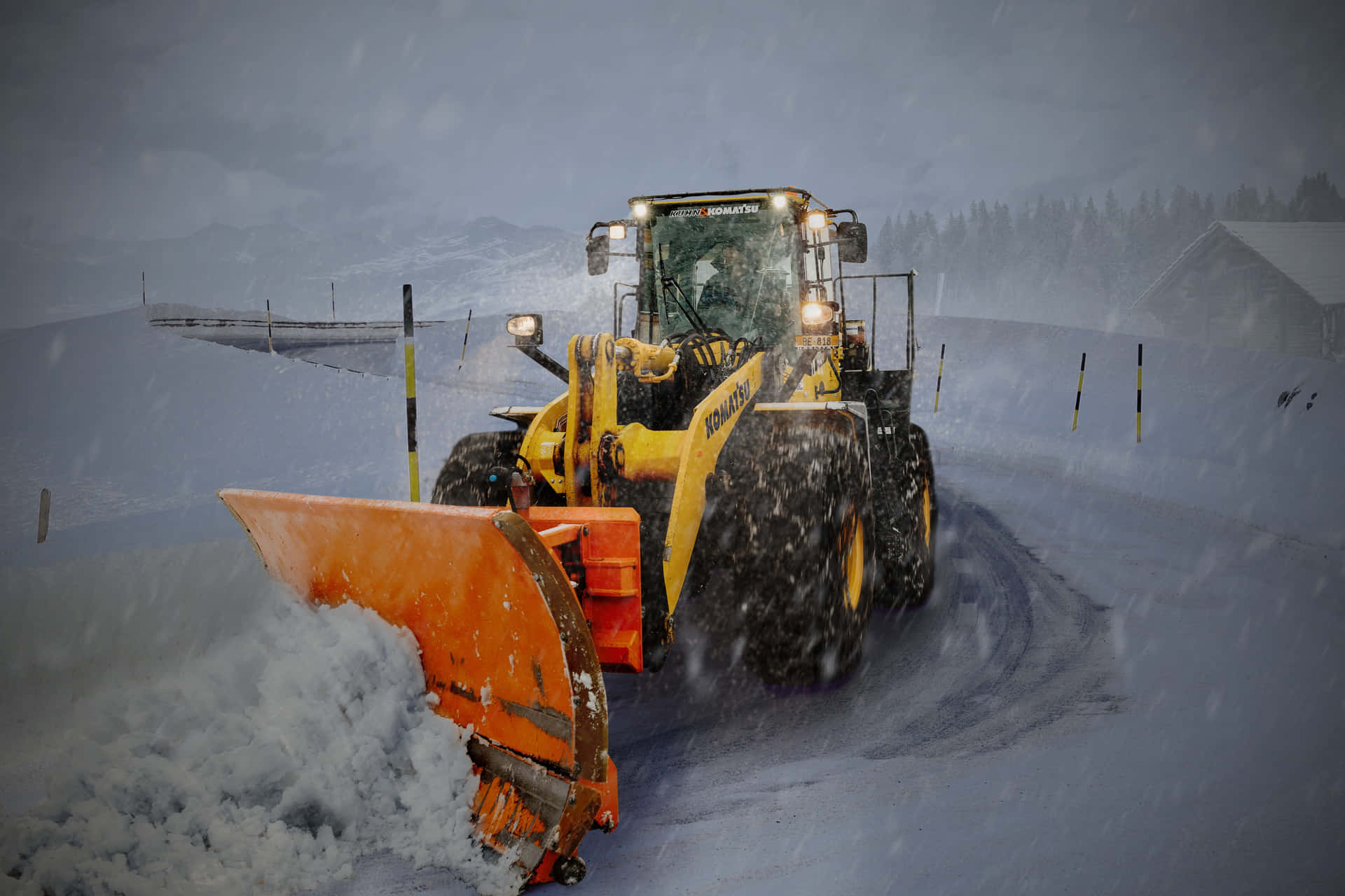 Snowplow clearing a snow-covered road during a heavy snowstorm Wallpaper