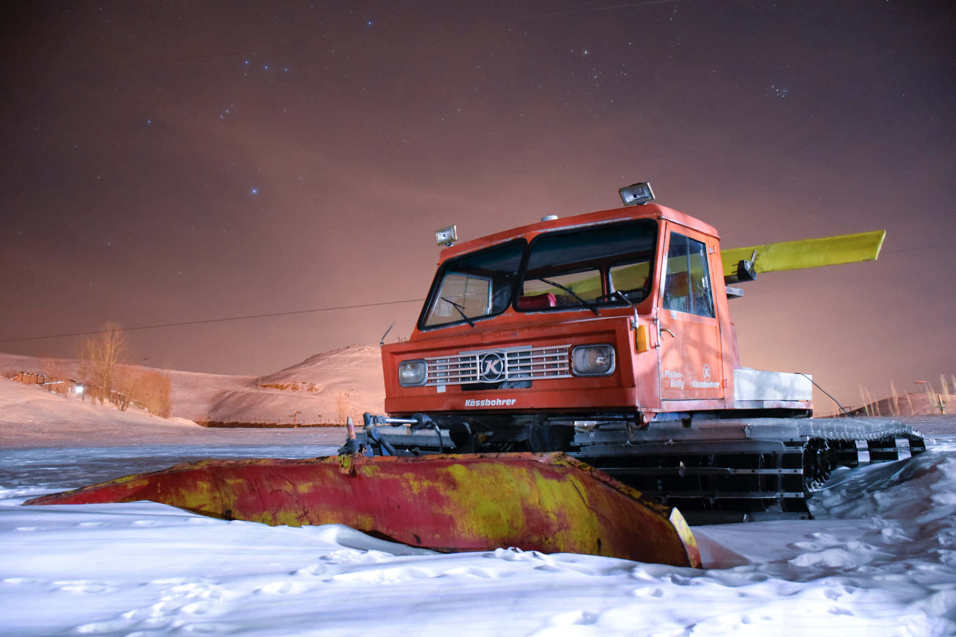 Powerful snowplow clearing the road during a heavy snowfall Wallpaper