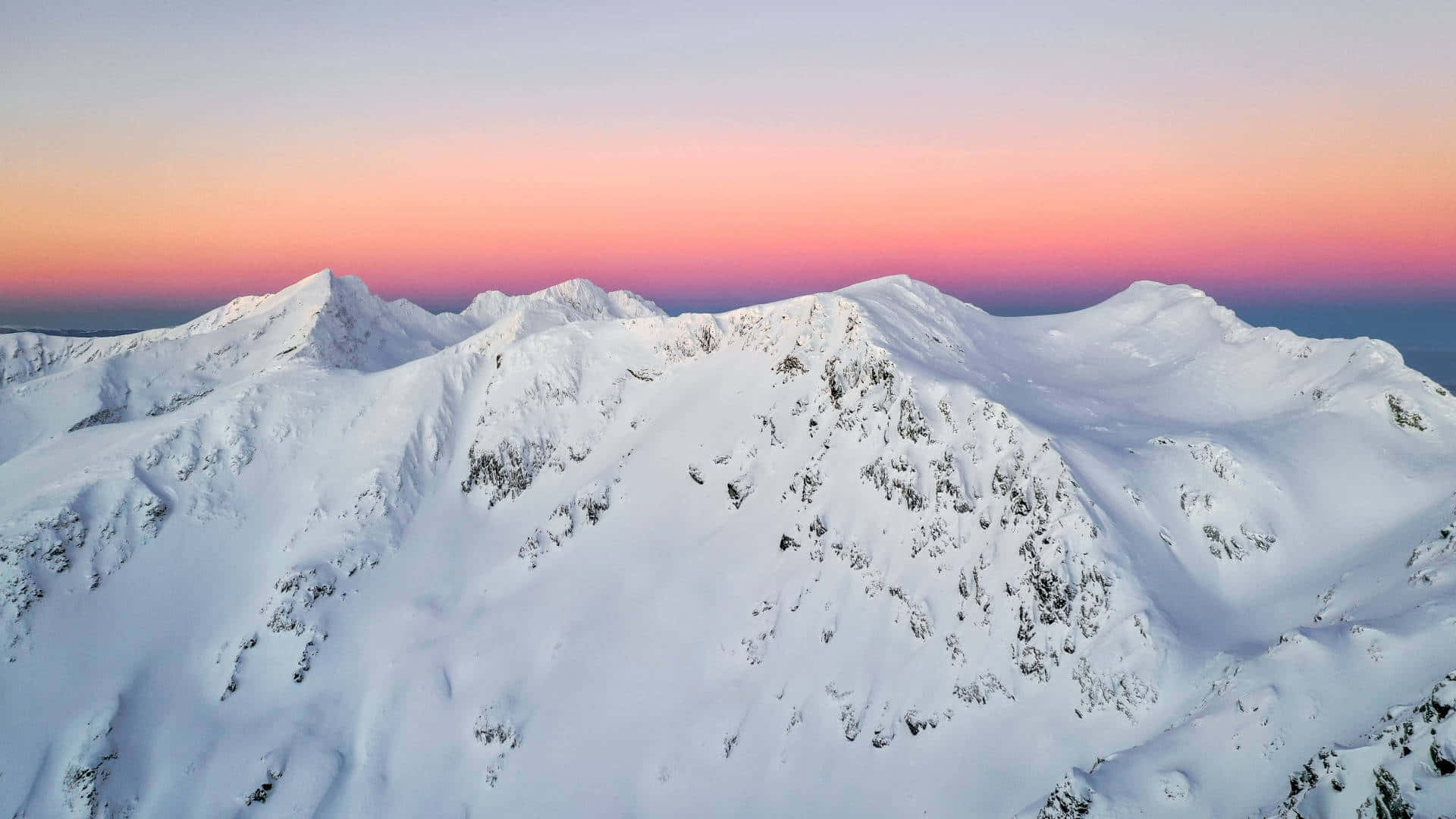 Snowy Mountain Peaksat Sunset Wallpaper