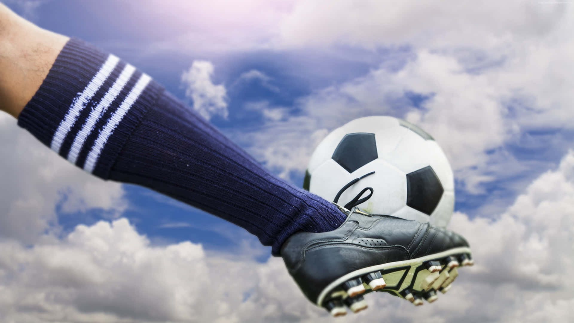 Soccer Cleat Kicking Ball Against Sky Wallpaper