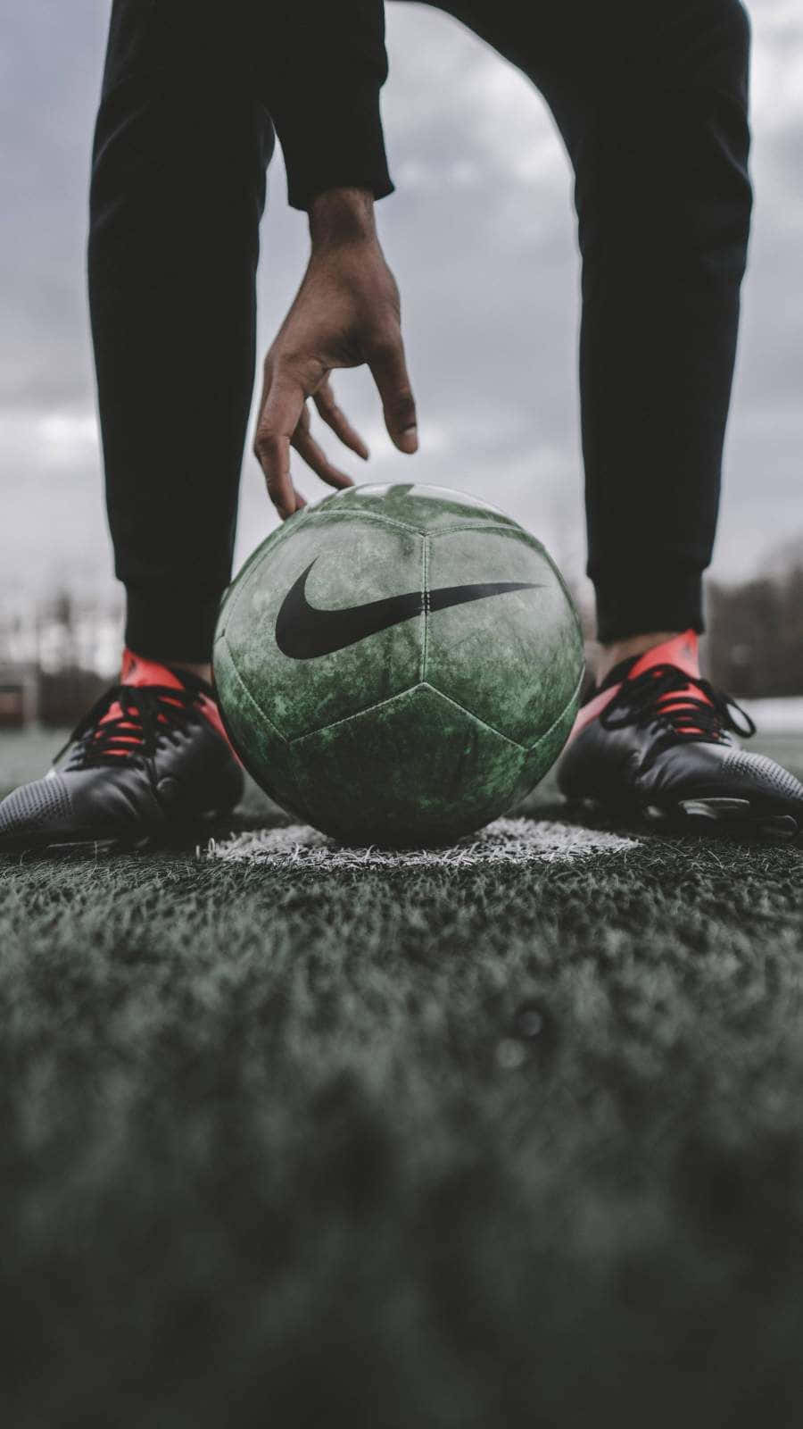 A Person's Feet Are Positioned On A Soccer Ball Wallpaper