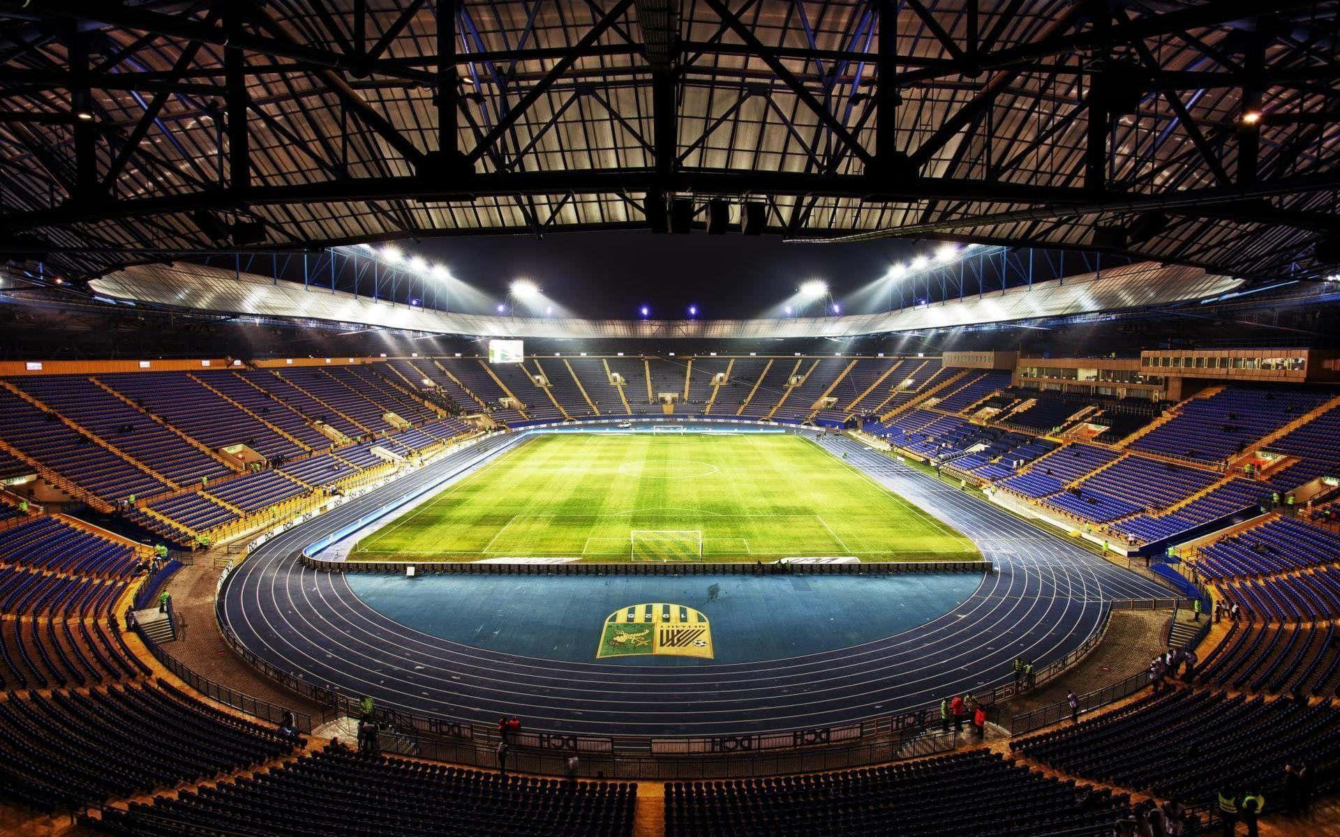 Et luftfoto af et fodboldstadion på kampdag Wallpaper