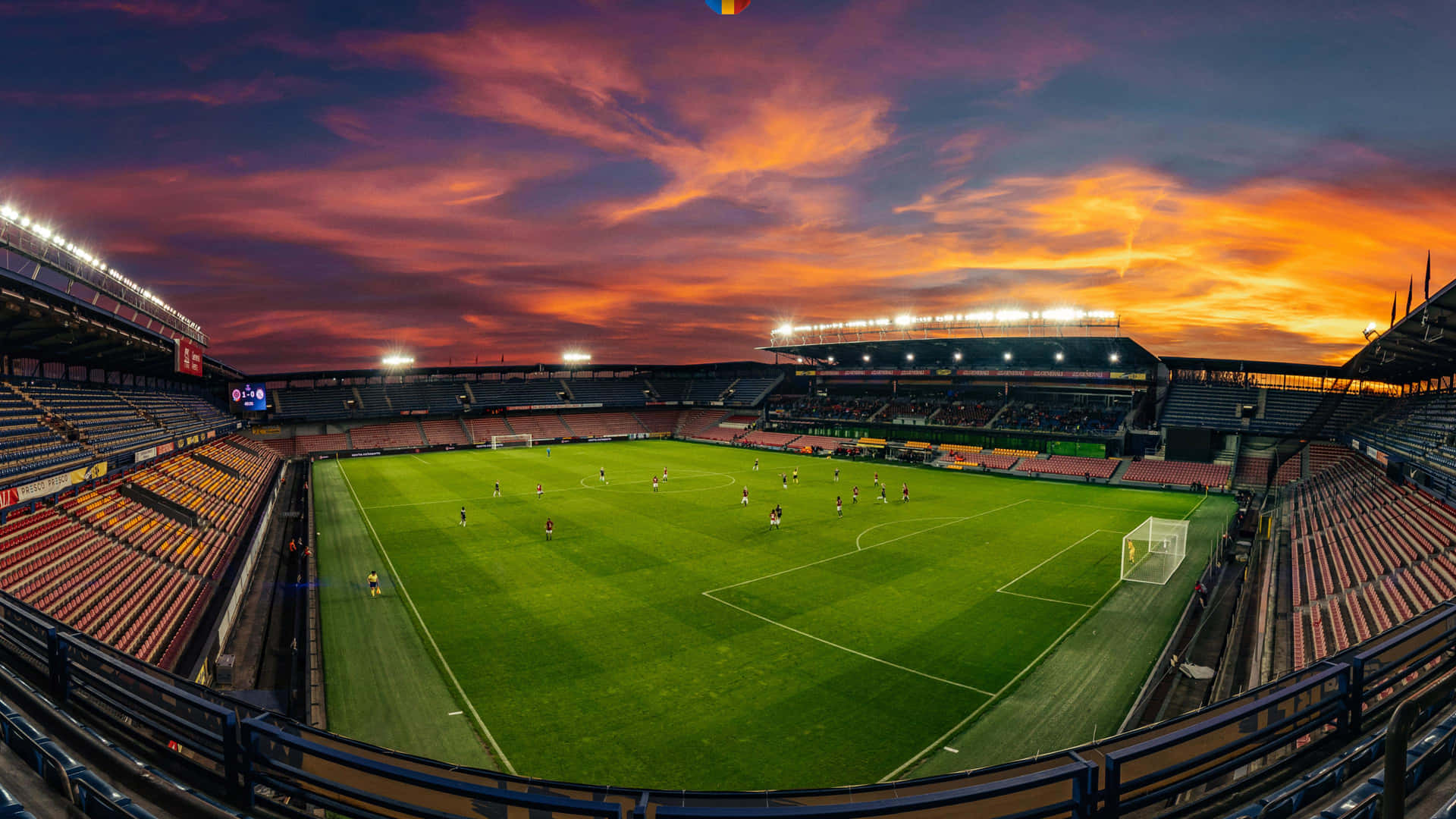Et fodboldstadion med en solnedgang himmel. Wallpaper