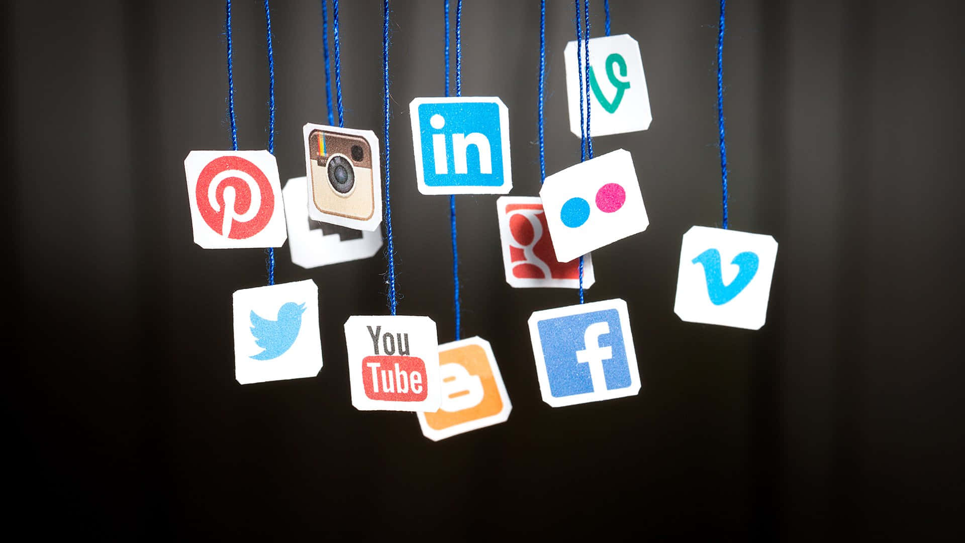Social Media Icons Hanging From Strings Wallpaper