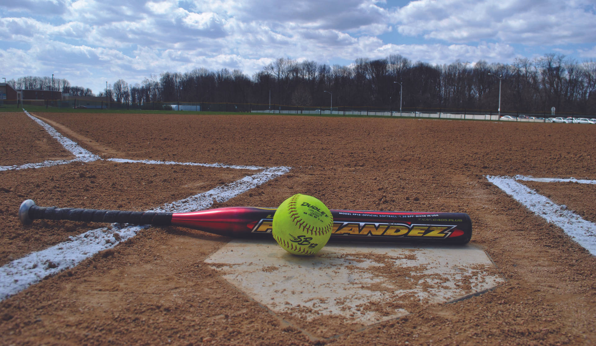 Softball And Bat On The Field Wallpaper