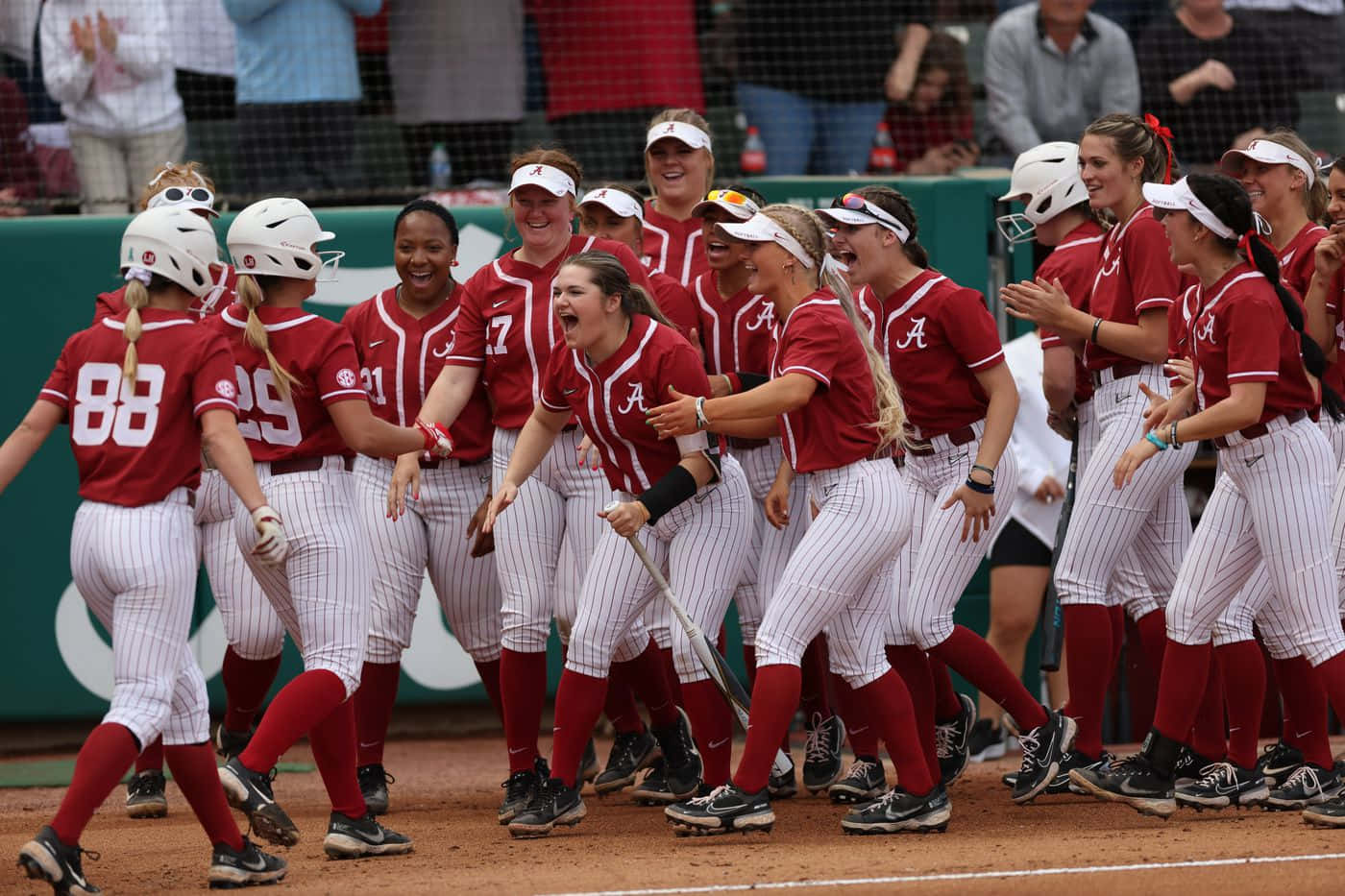 A Group Of Softball Players Celebrating On The Field