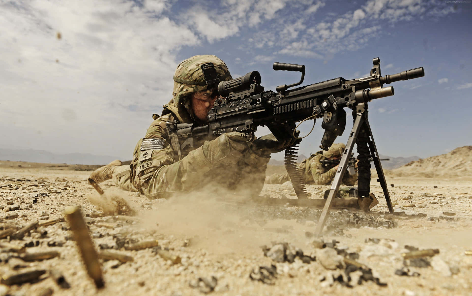 Soldier_ Firing_ Machine_ Gun_ Desert Wallpaper