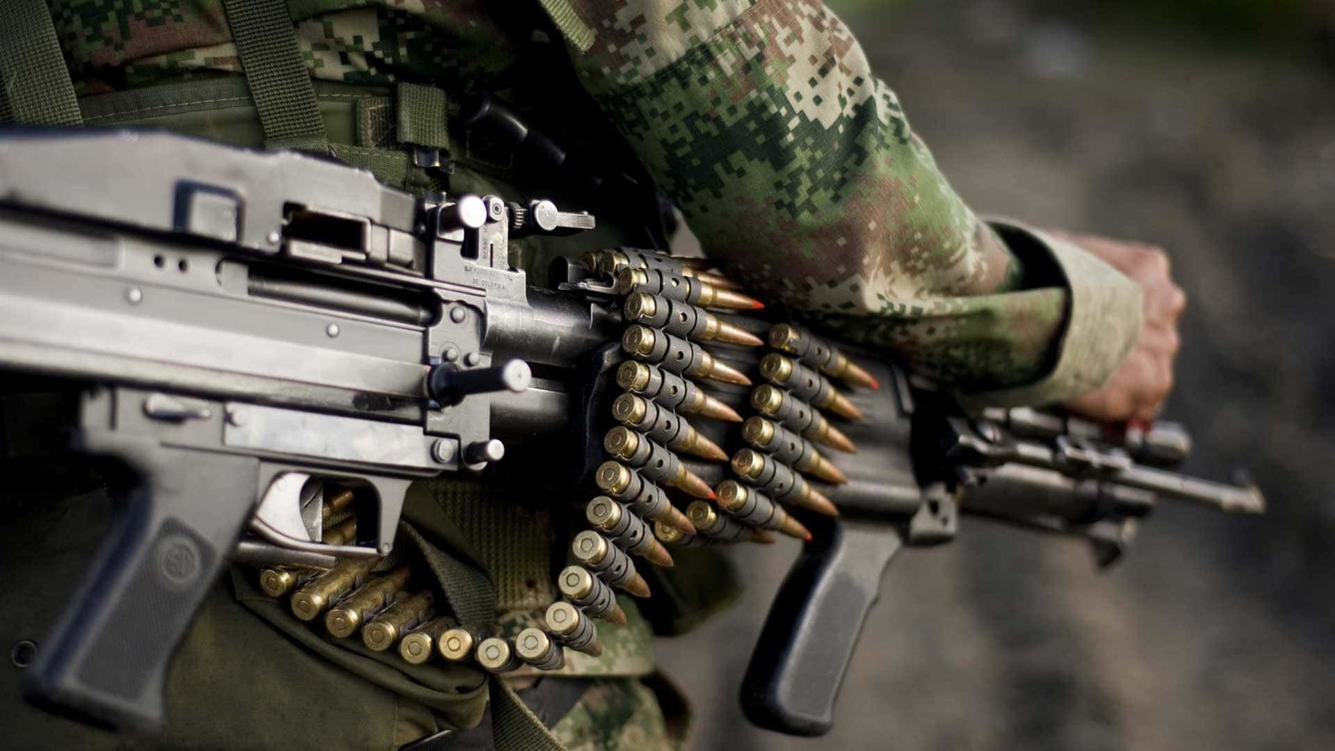 Soldier_ Holding_ Machine_ Gun_with_ Ammunition_ Belt.jpg Wallpaper