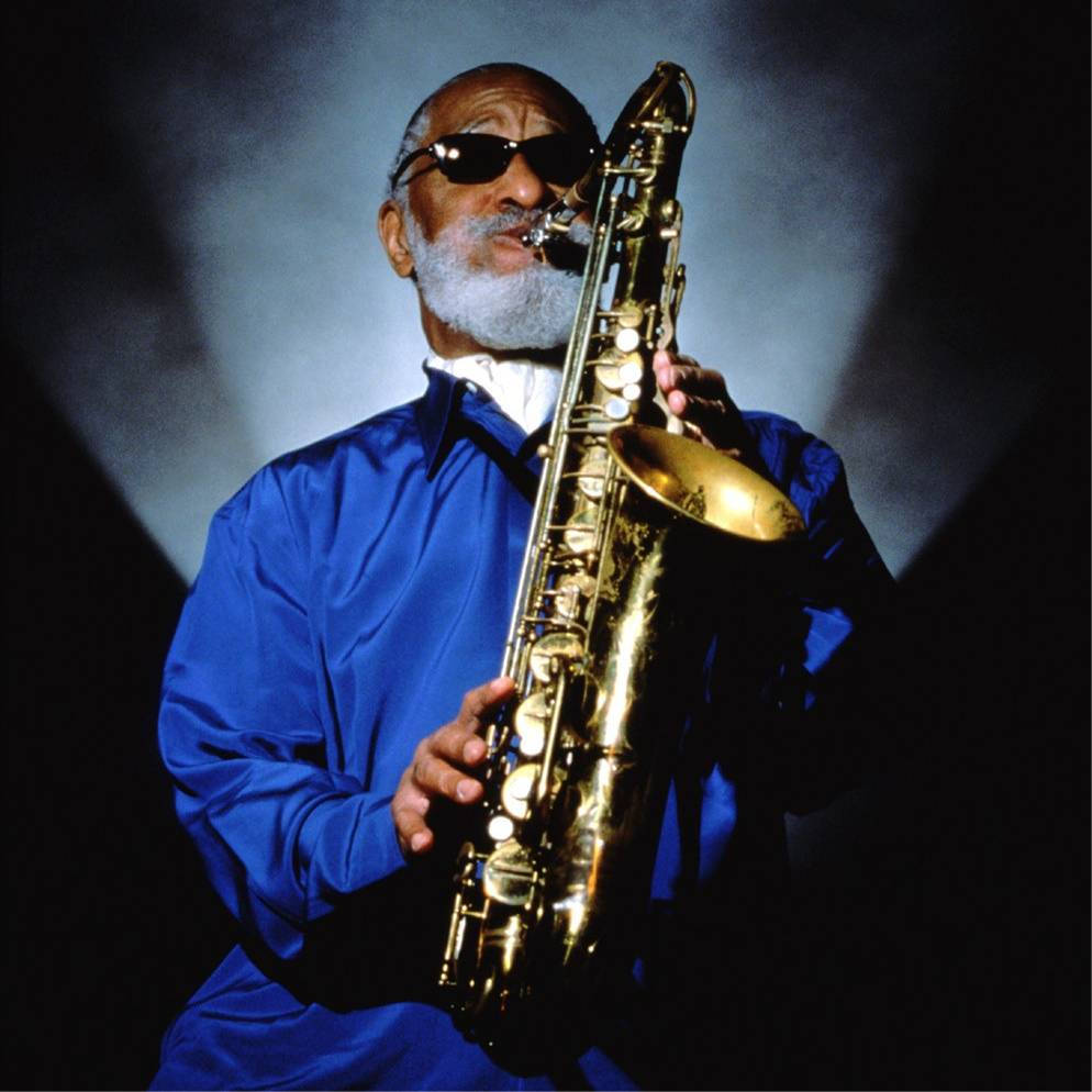 Sonny Rollins In Blue And With Shades On Wallpaper