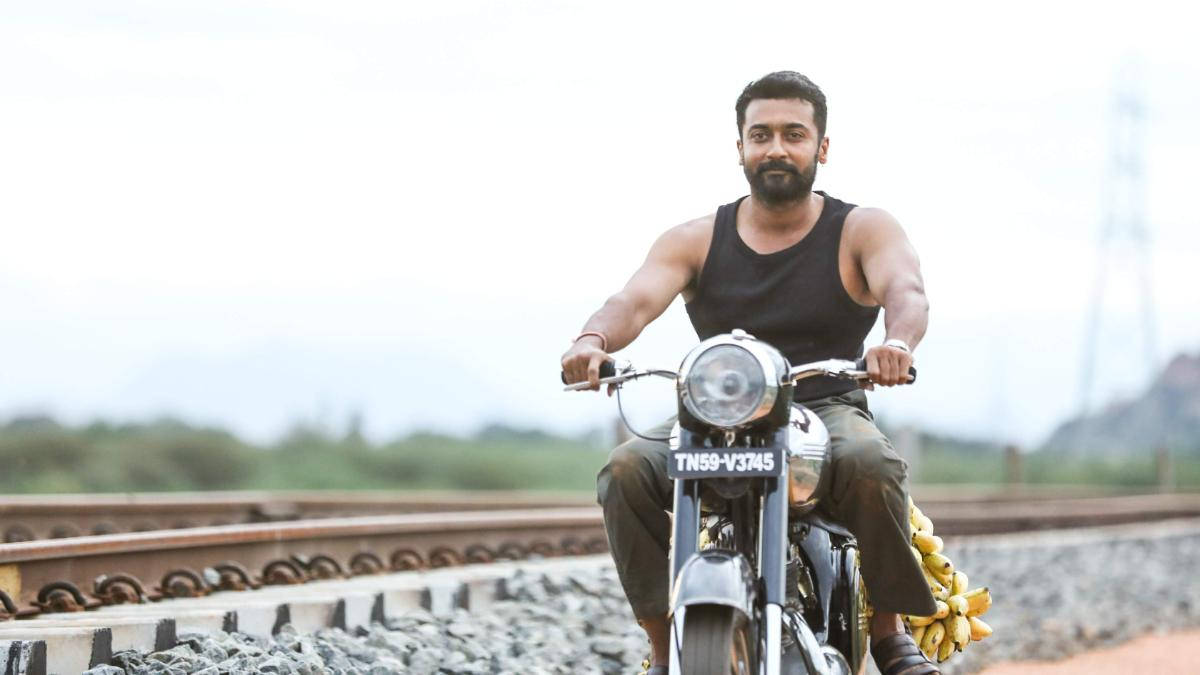 Soorarai Pottru Suriya On Motorcycle Near Tracks Background