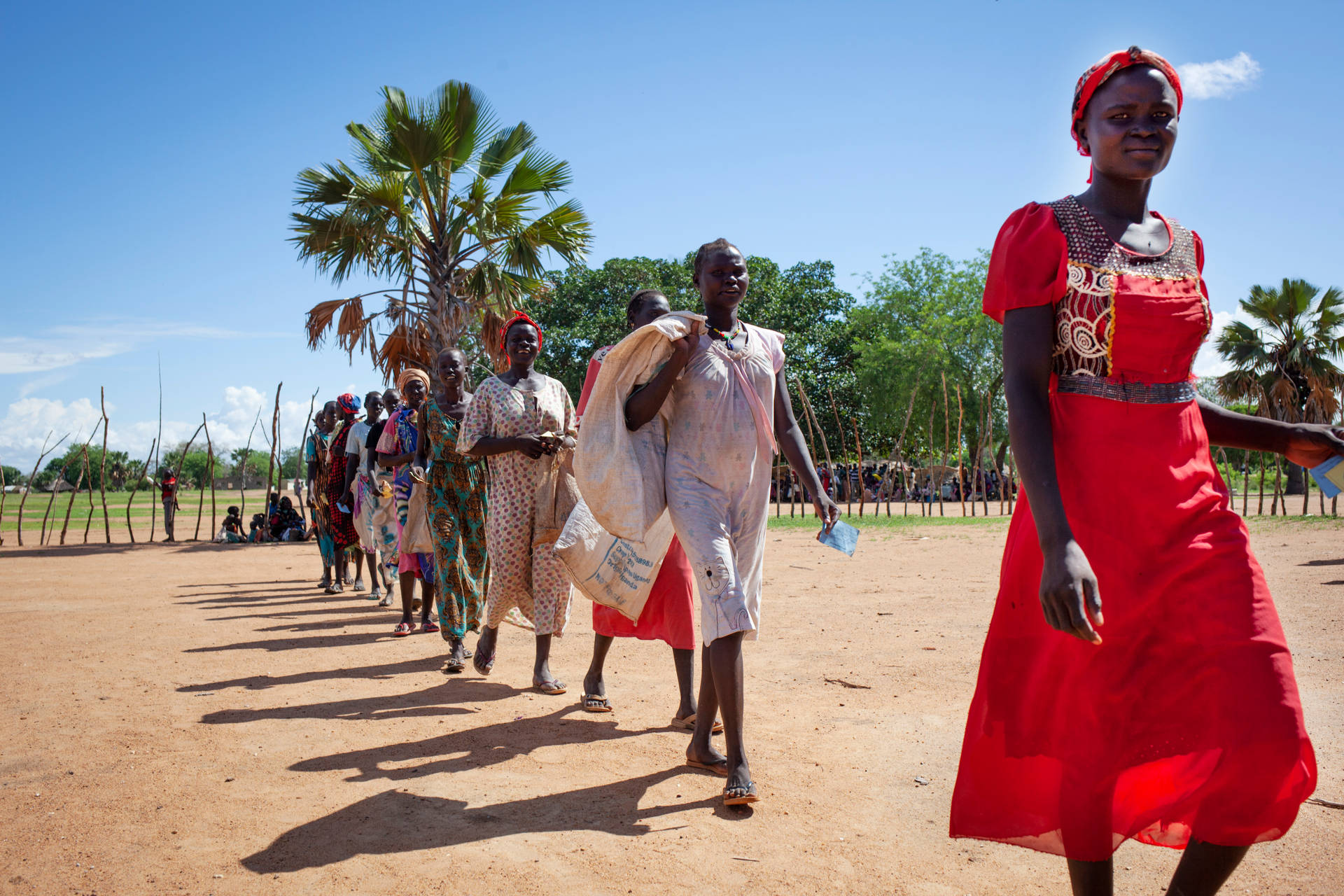 Südsudanesischefrauen In Traditionellen Kleidern Beim Gehen Wallpaper