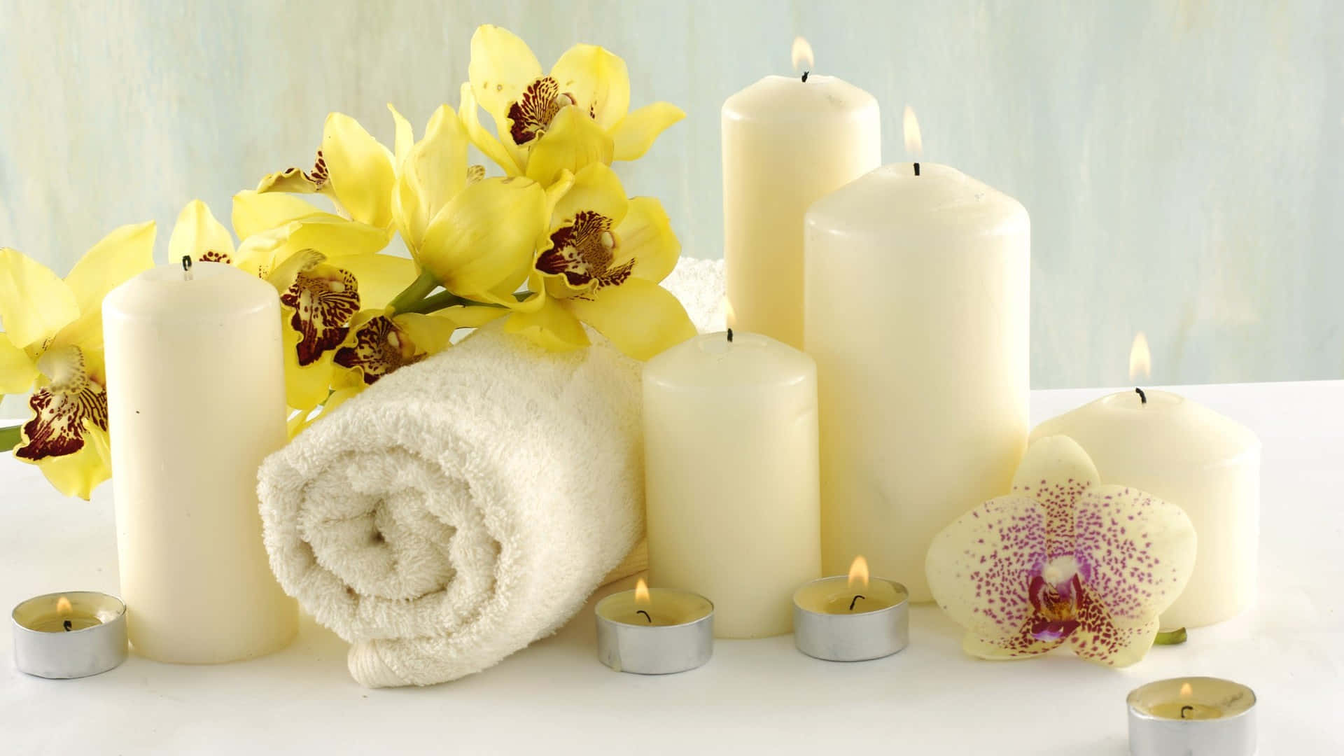 Wellnesshintergrund Mit Großen Weißen Kerzen, Handtüchern Und Gelben Blumen