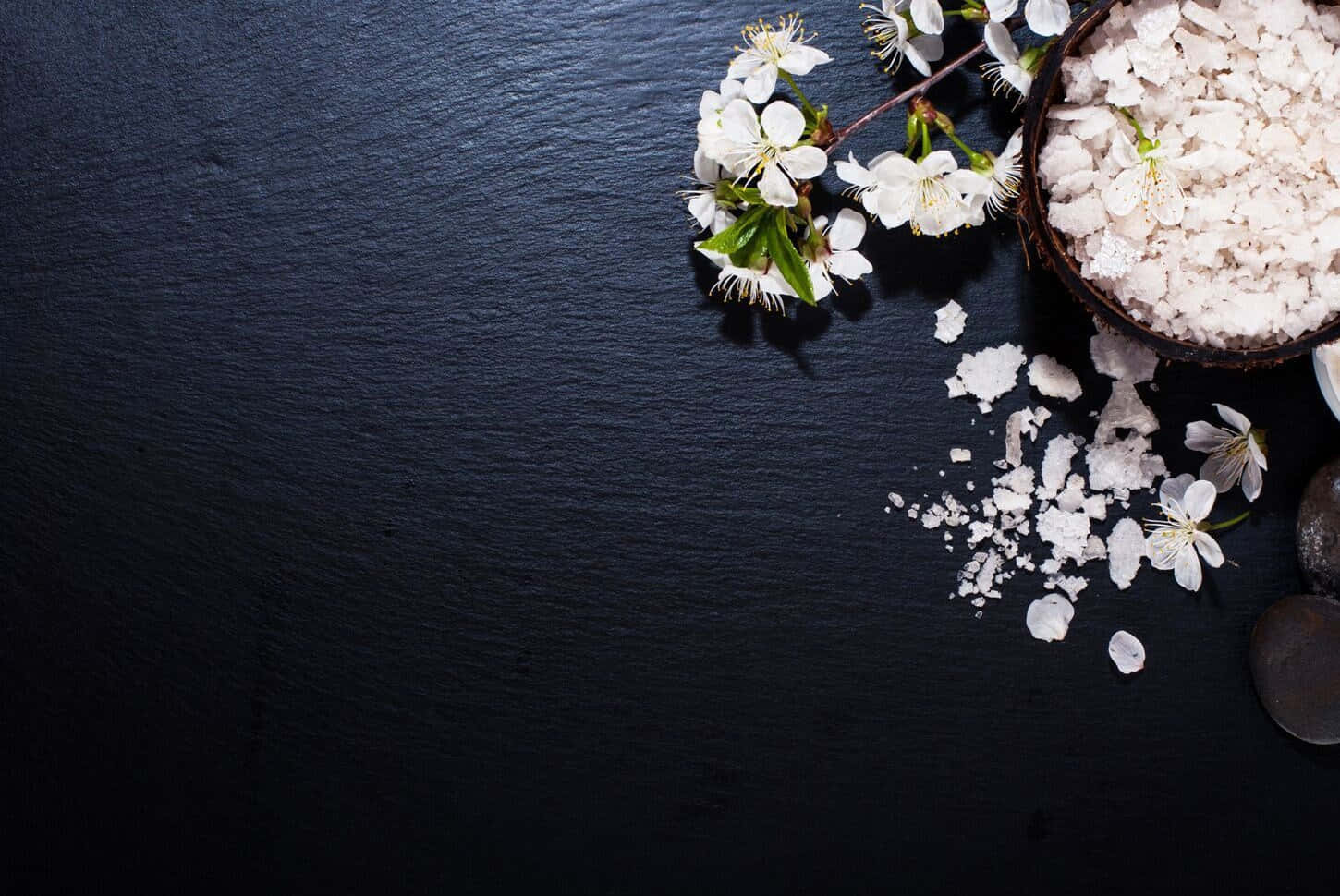 Sort baggrund med hvide blomster på en sort træoverflade