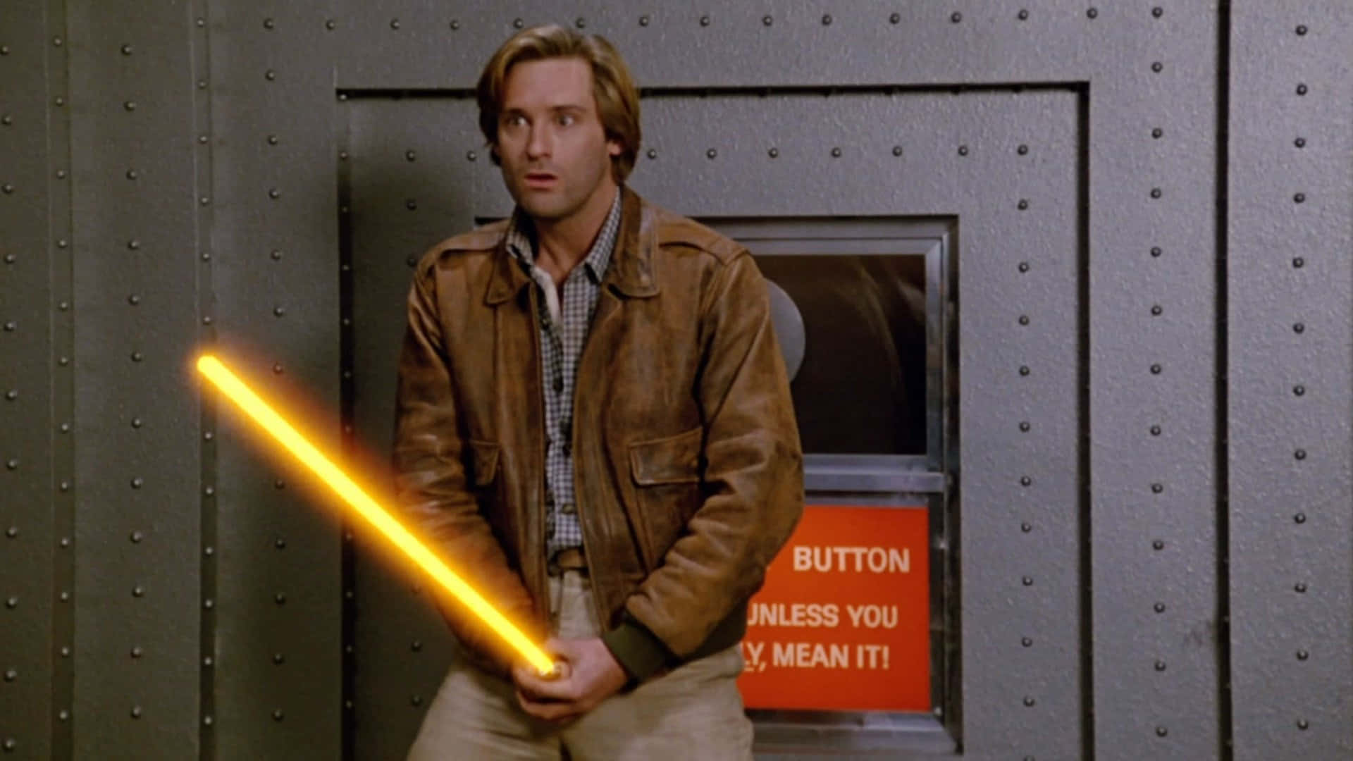 A Man Holding A Yellow Light Saber In Front Of A Door Wallpaper