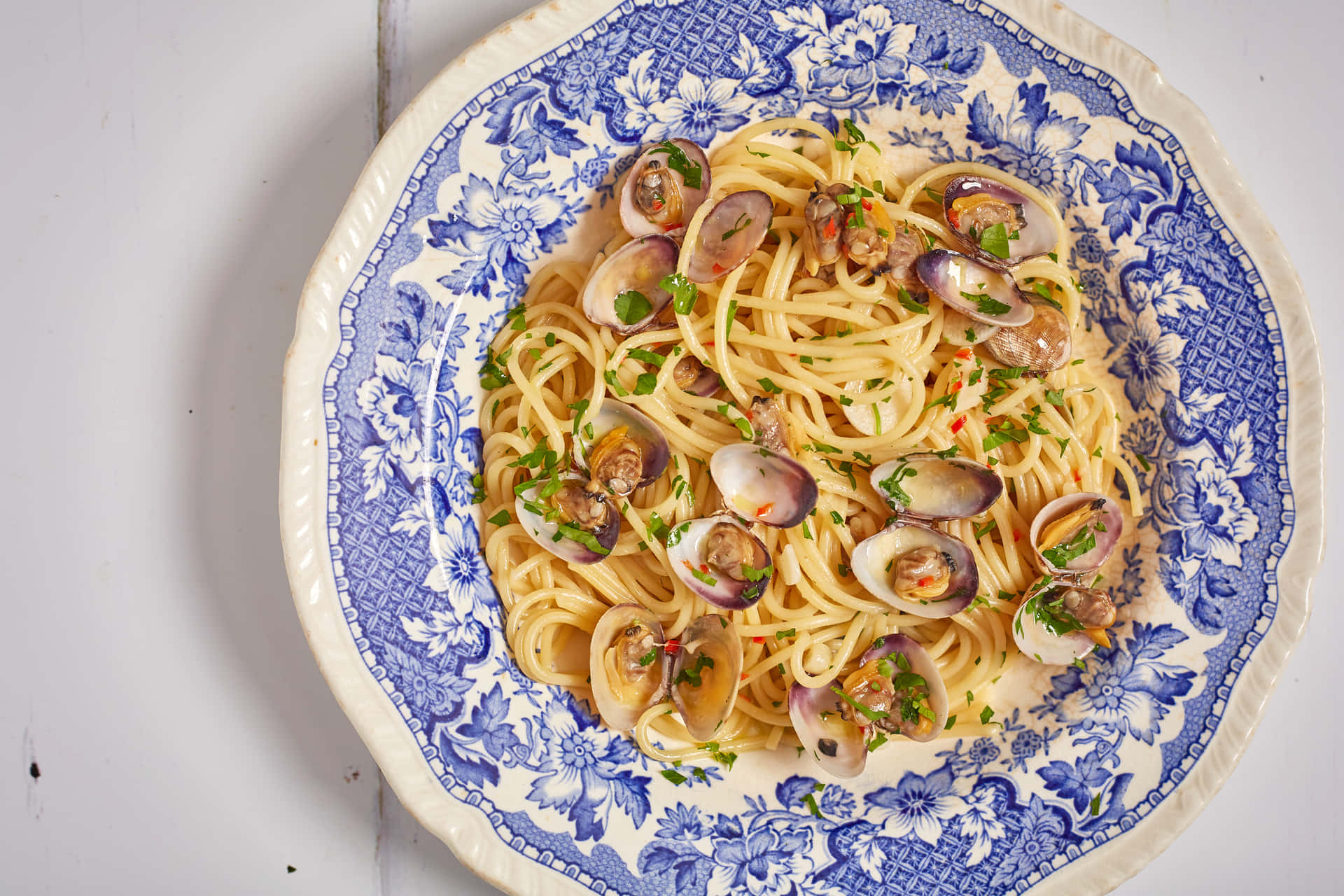 Delicious Spaghetti Alla Vongole Served on a Floral Porcelain Plate Wallpaper